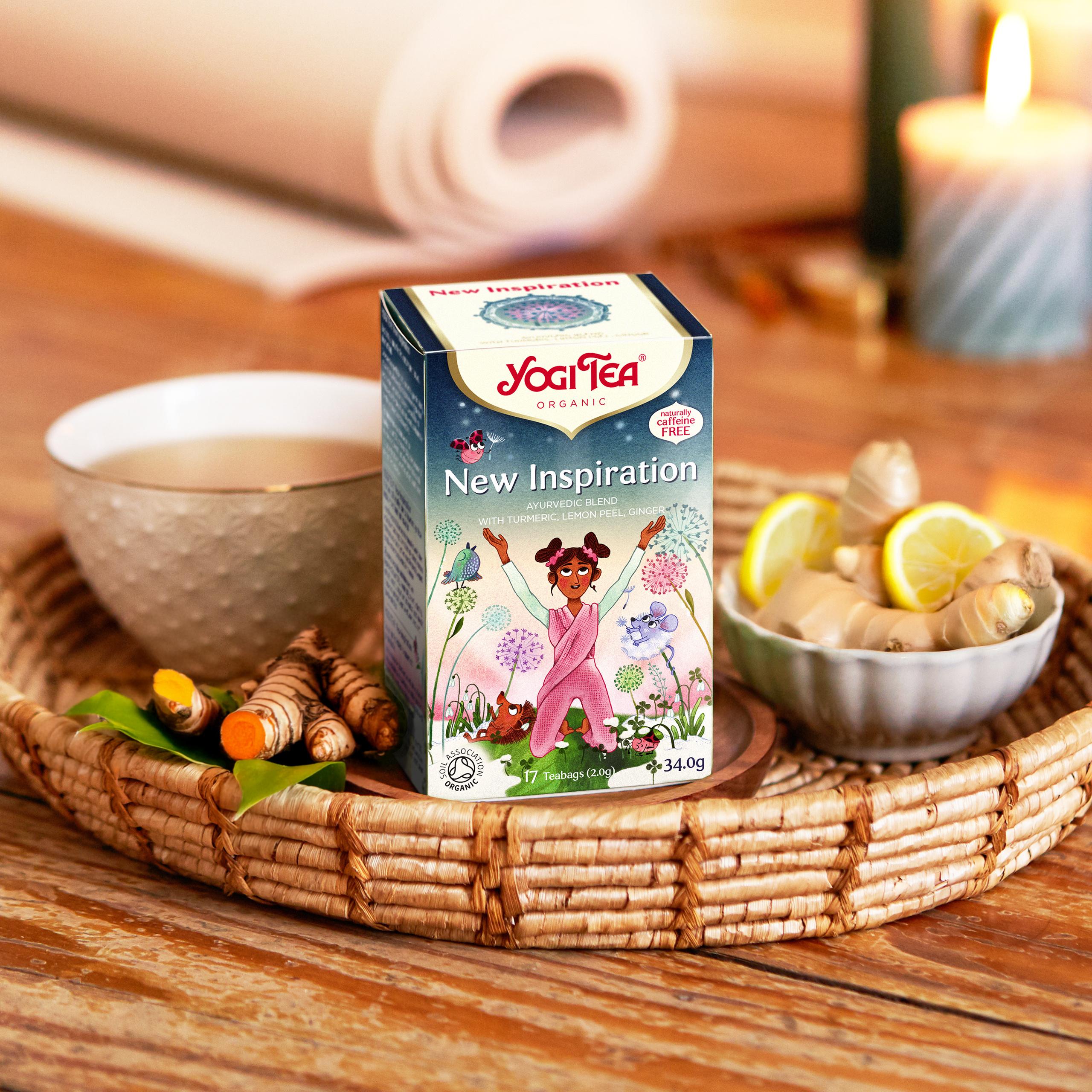 Yogi Tea New Inspiration organic herbal tea with turmeric, ginger and lemon on woven tray with candle and teacup