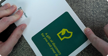 Hands holding a folded card with a green cover