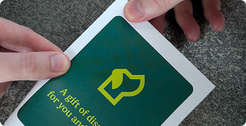 Hands performing a horizontal fold on the printed card design