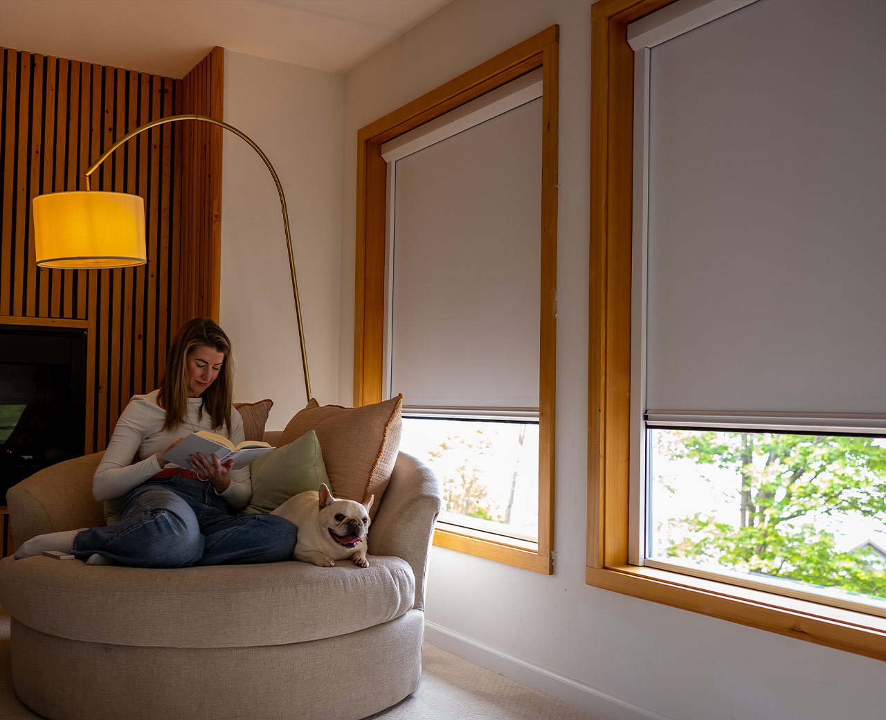 Woman-reading-with-dog-in-modern-living-room-with-blackout-roller-shades-on-windows.jpg