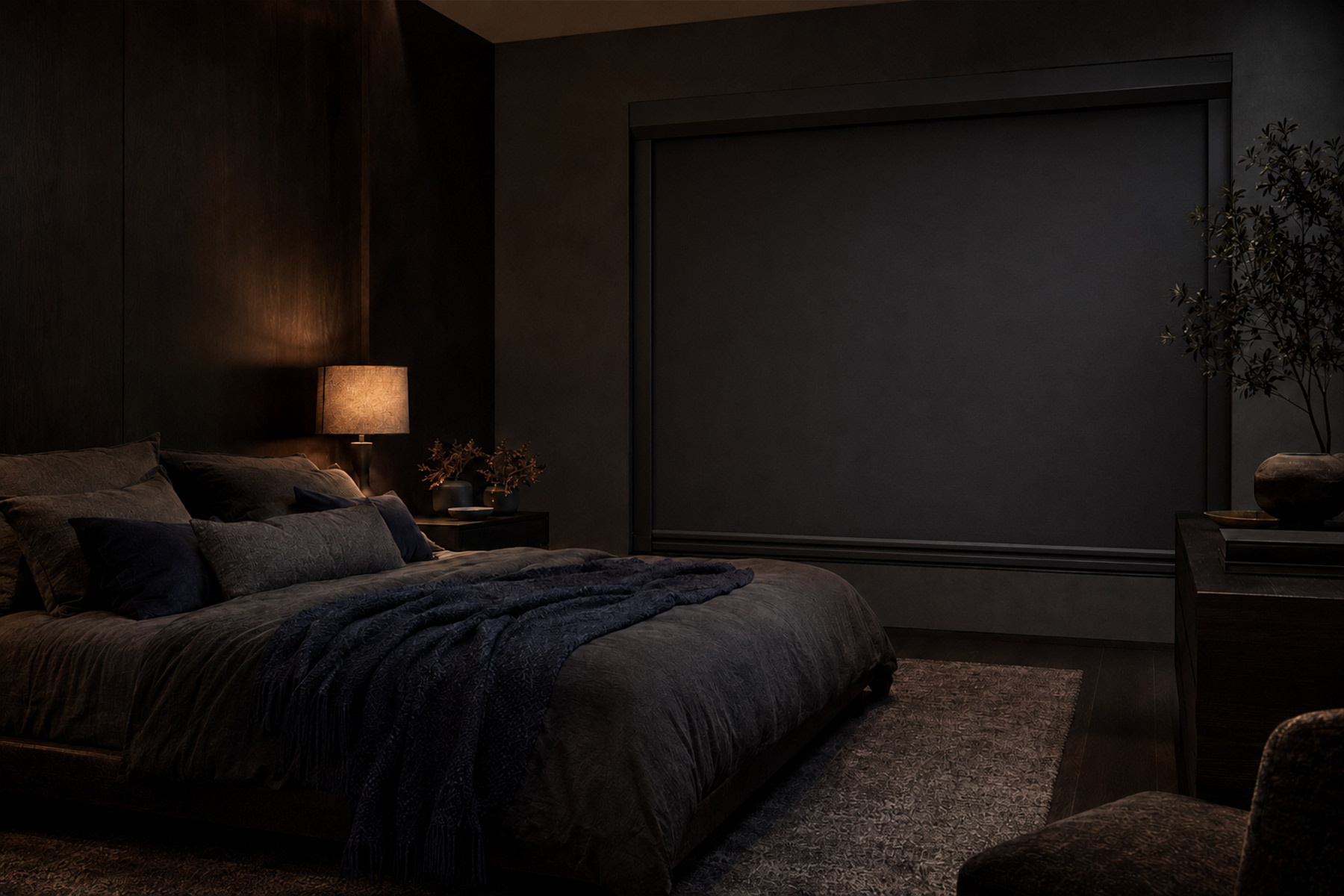 Moody dark bedroom with charcoal walls, layered linen and a single warm bedside lamp