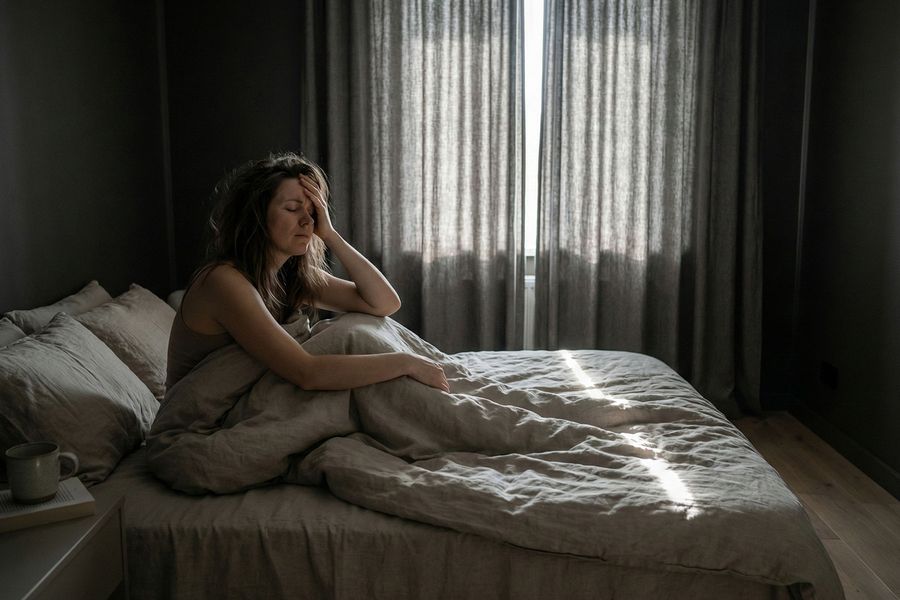 Stressed lady in bed unable to sleep due to light leak 