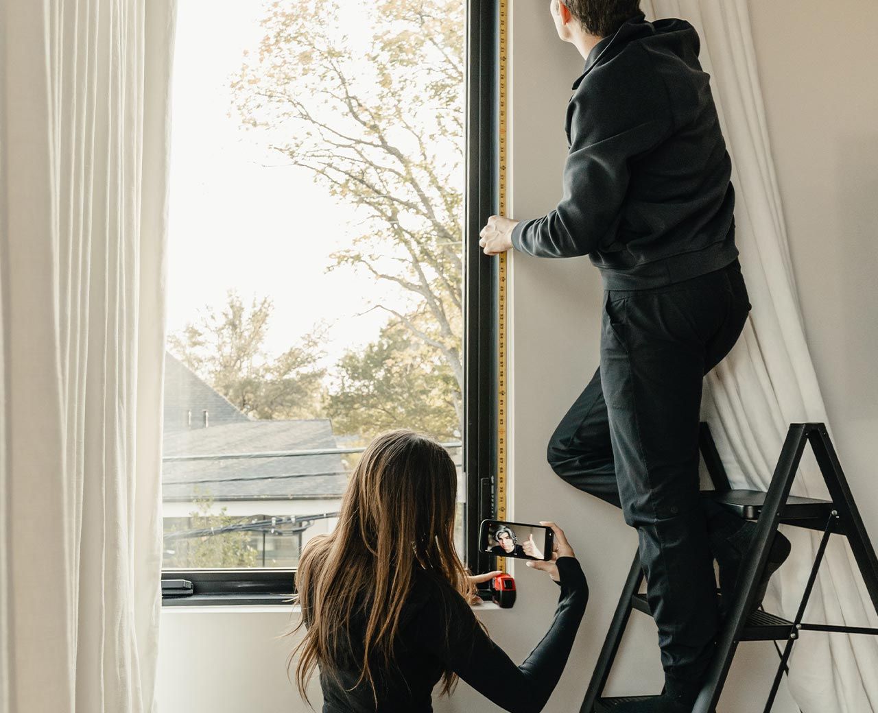 Couple installing UBlockout sealed track shade 