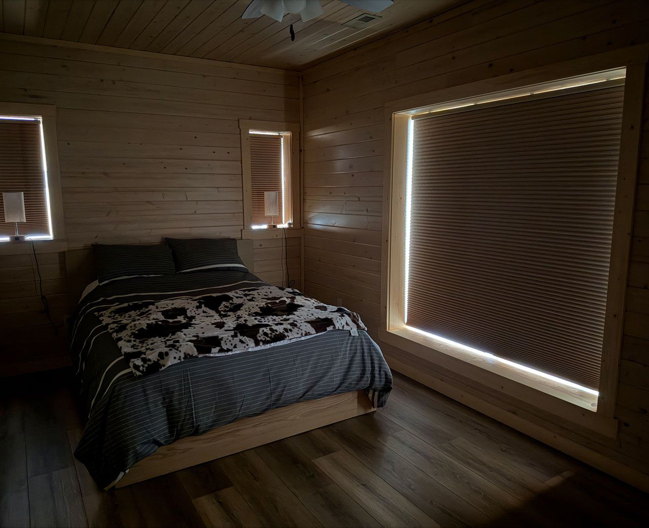 Bedroom with cellular shades showing bright halo of light leaking around all four edges of every window during daytime