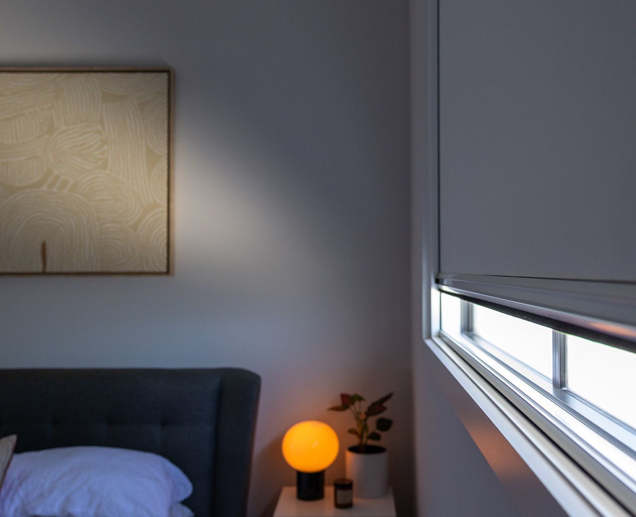 uBlockout blackout shades being lowered in a dark bedroom to block outside light