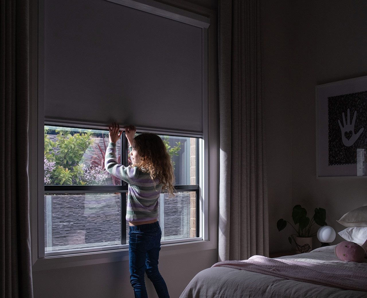 Child adjusting uBlockout shade on bedroom window to reduce incoming daylight