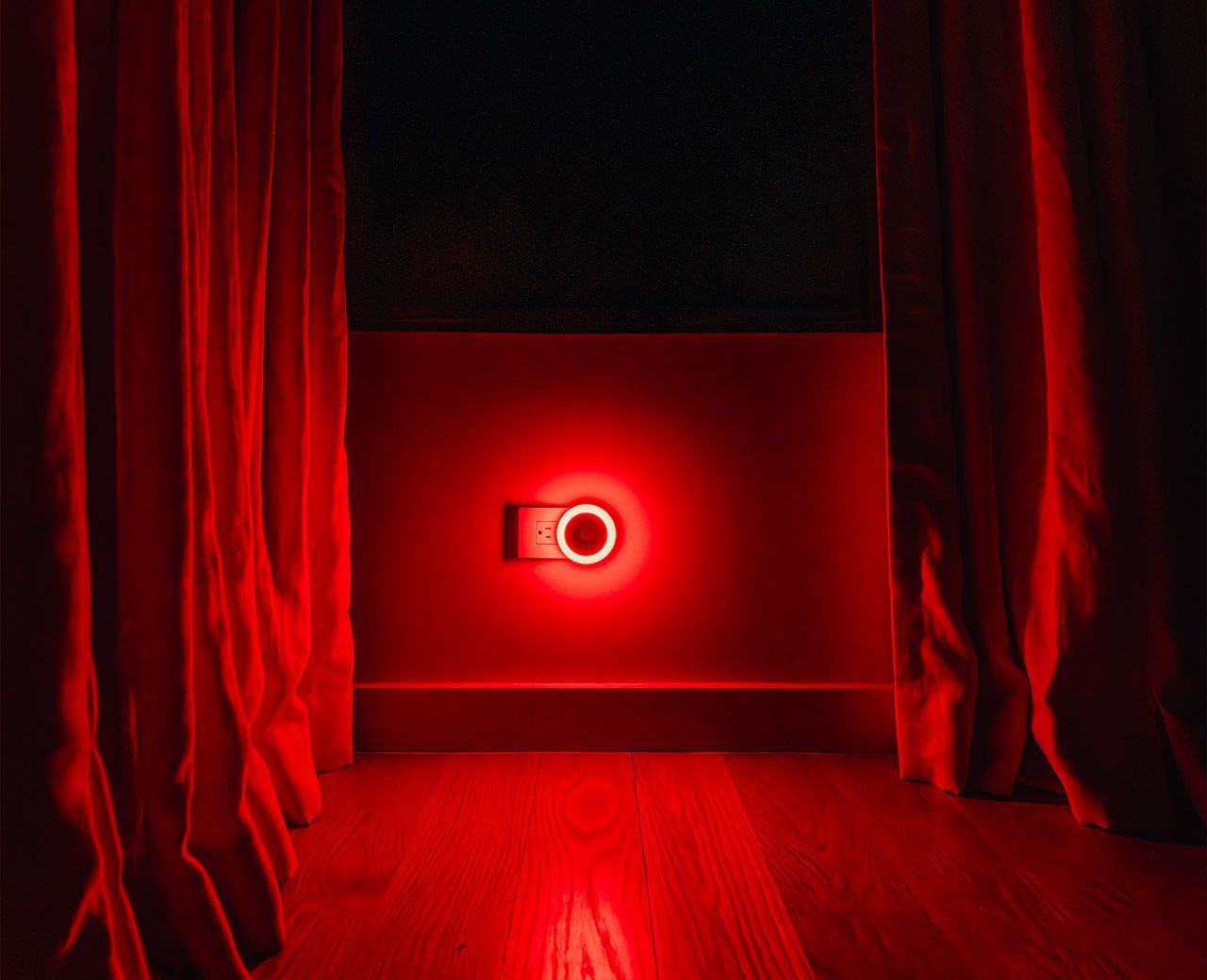 uBlockout red light motion sensor night light glowing in dark room between blackout curtains