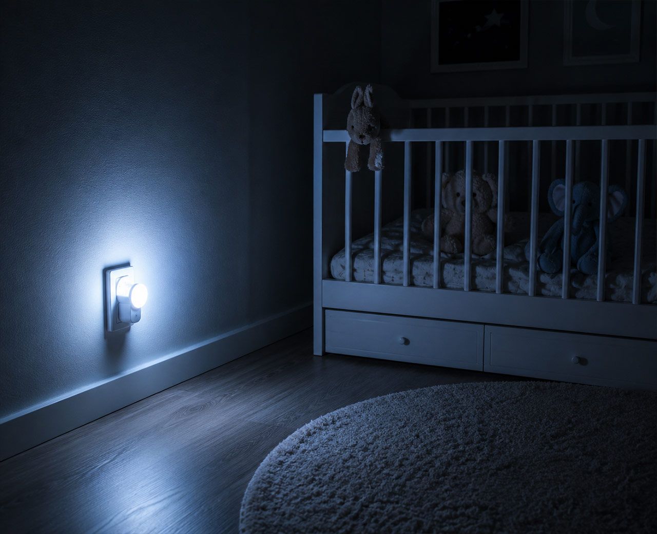  A bright white nightlight casting a strong glow across the floor of a dark child's bedroom at night.