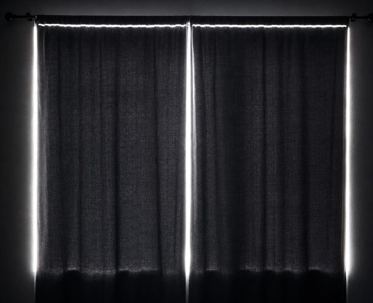 Daylight leaking around the top, sides and center seam of blackout curtains in an apartment