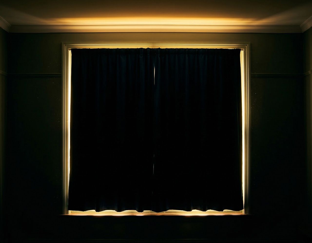 Dark blackout curtains on a large window with bright light visibly leaking around all four edges including the top sides and bottom creating a glowing frame outline