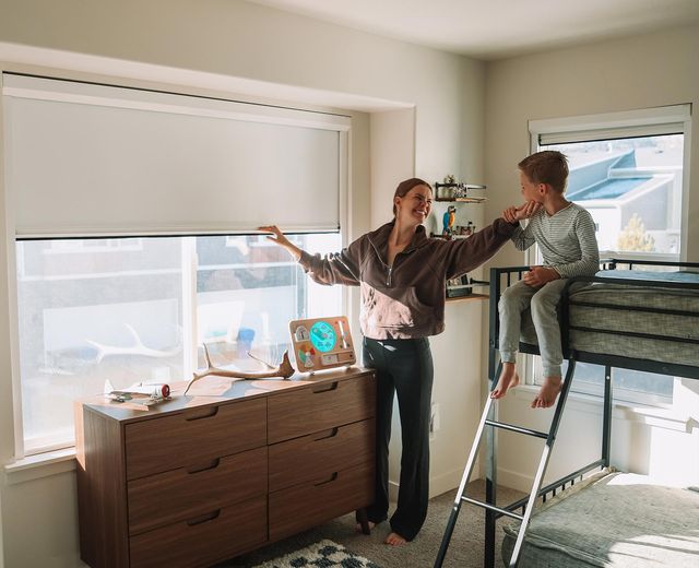 Mother and child in bright room with UBlockout shade installed on window