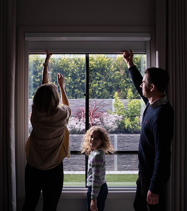 Family operating UBlockout blackout shade with sealed track technology