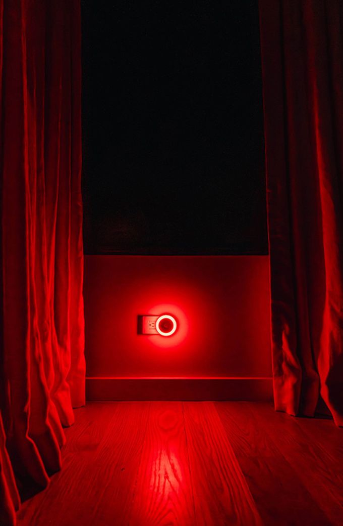 UBlockout Motion Sensor Night Light emitting 620nm red light in a dark bedroom beneath a blackout shade