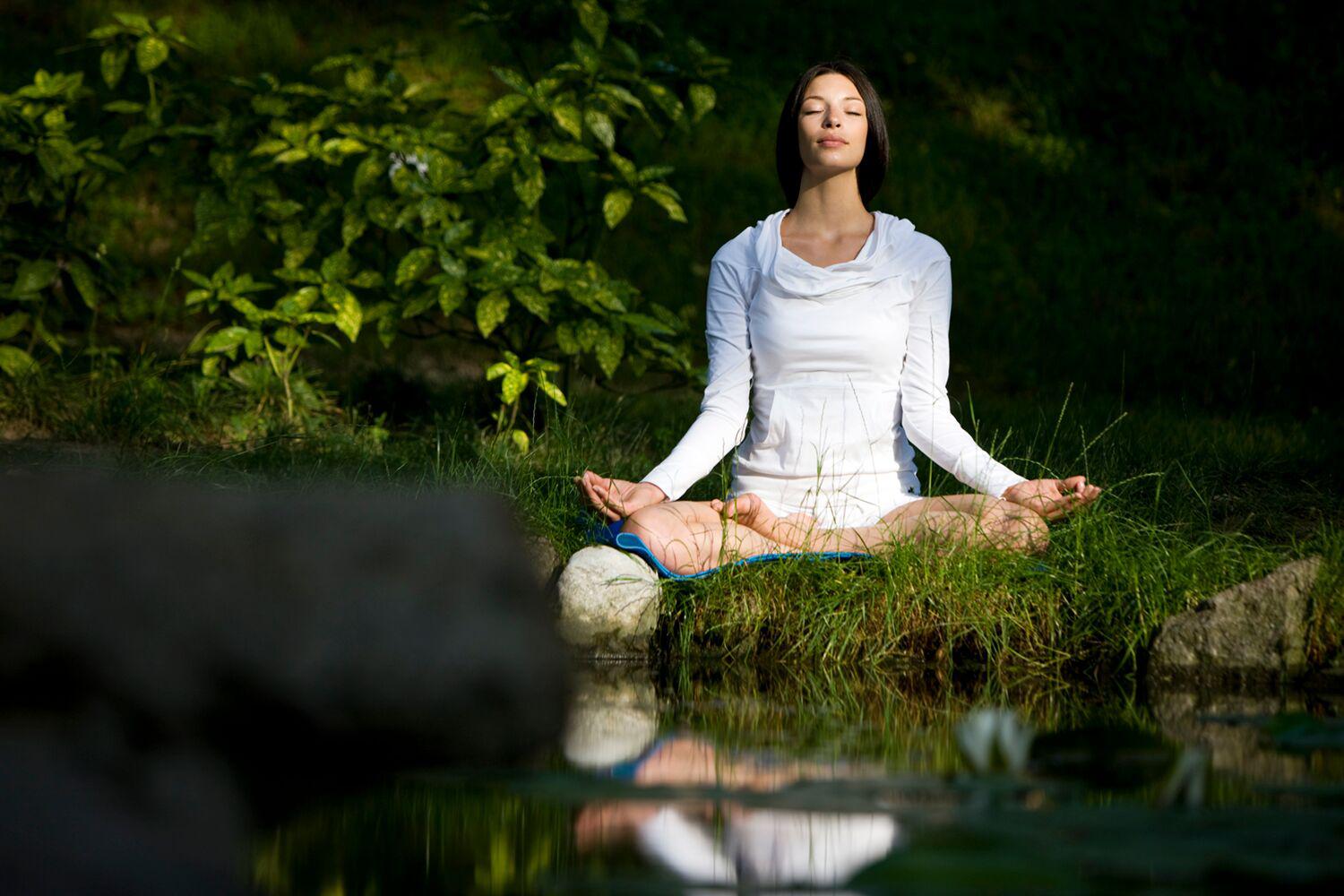 A woman meditating in the forest