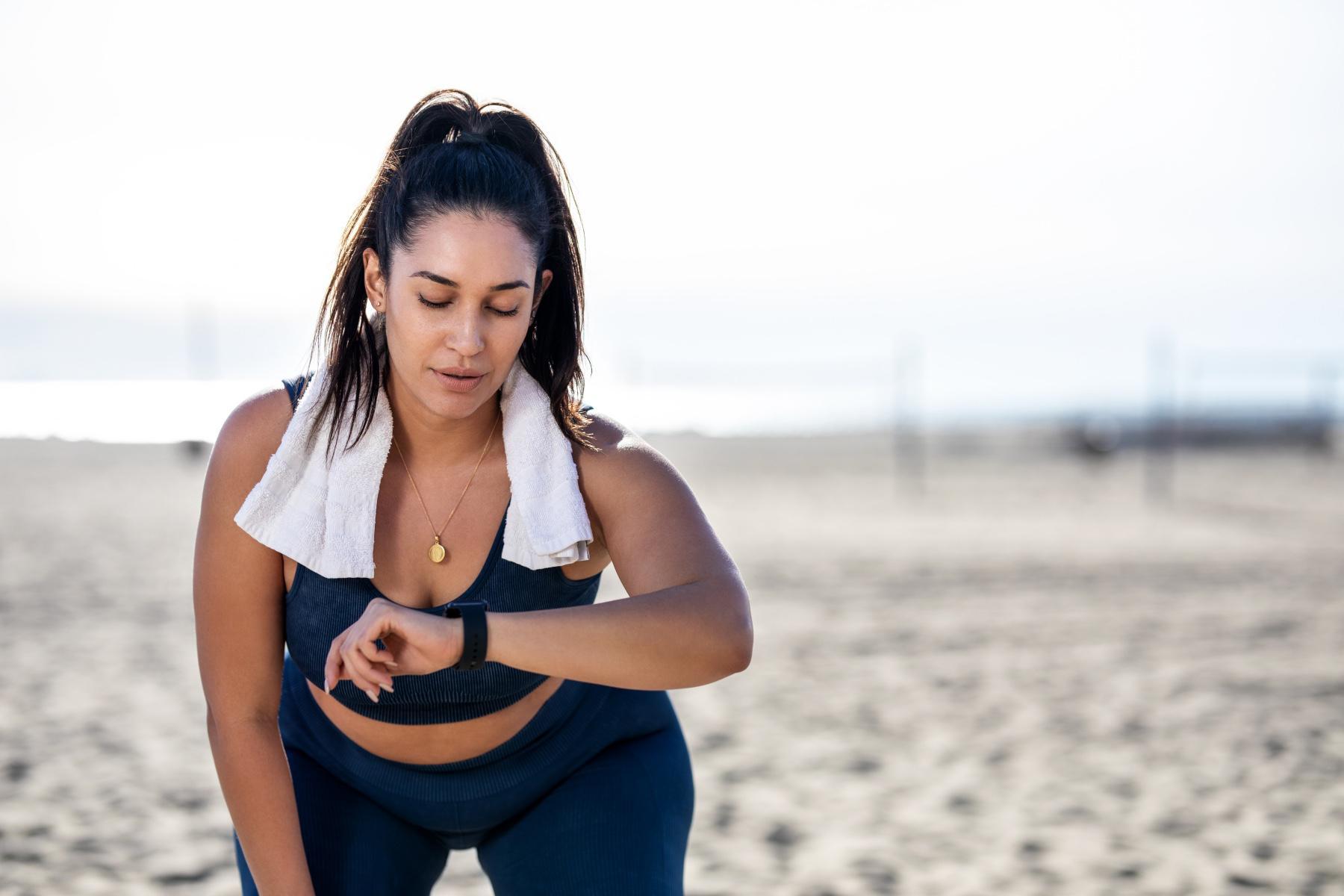 Athletic woman checking smart watch while working out.