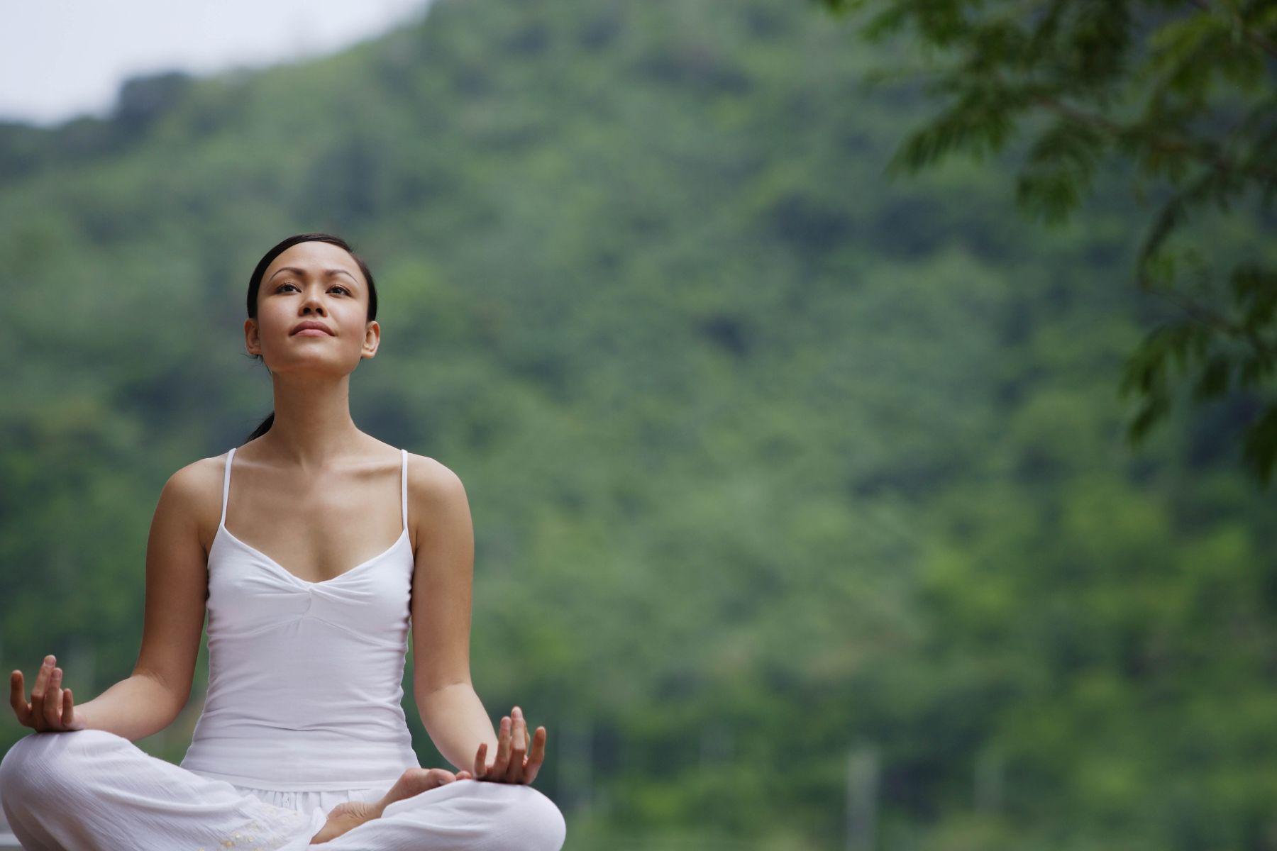 Woman meditating outside.
