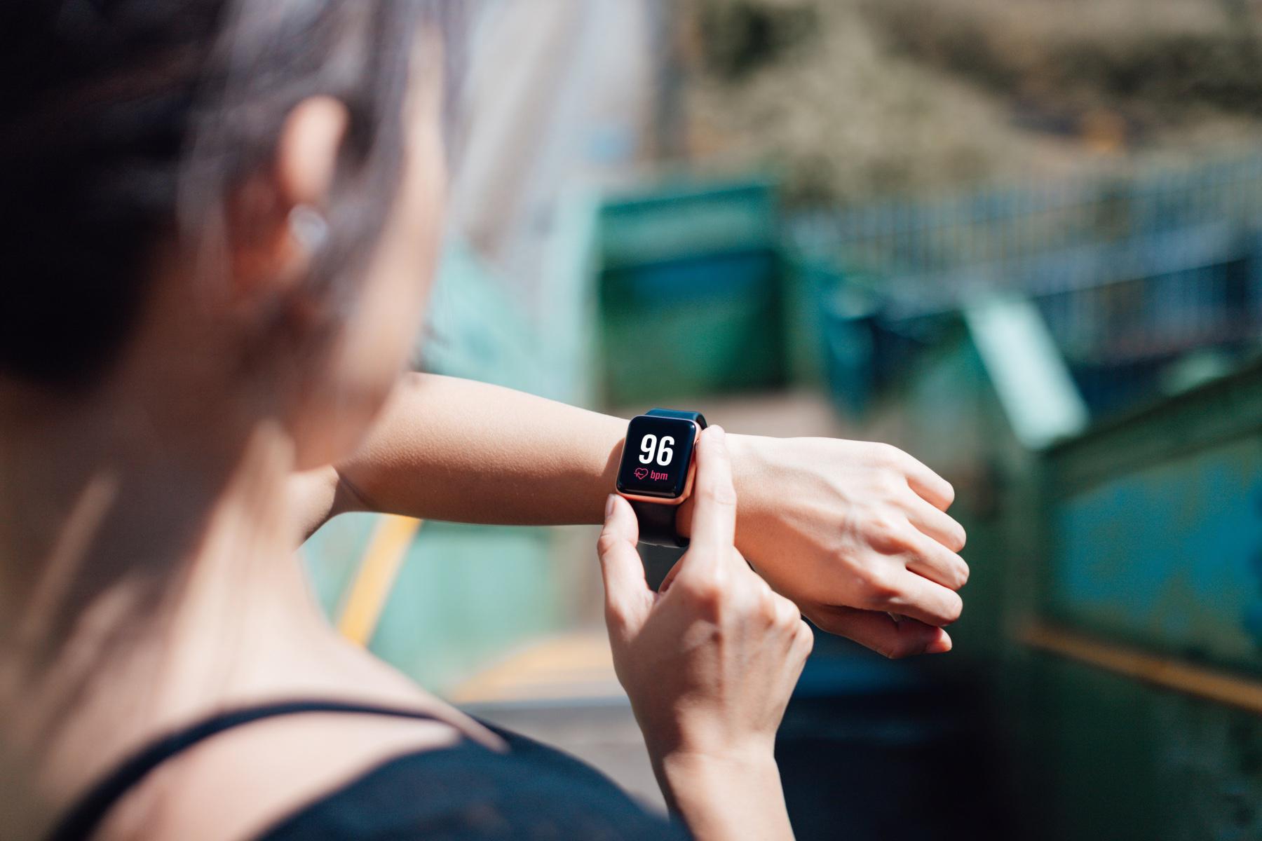 woman looking at heart rate on fitness tracker watch