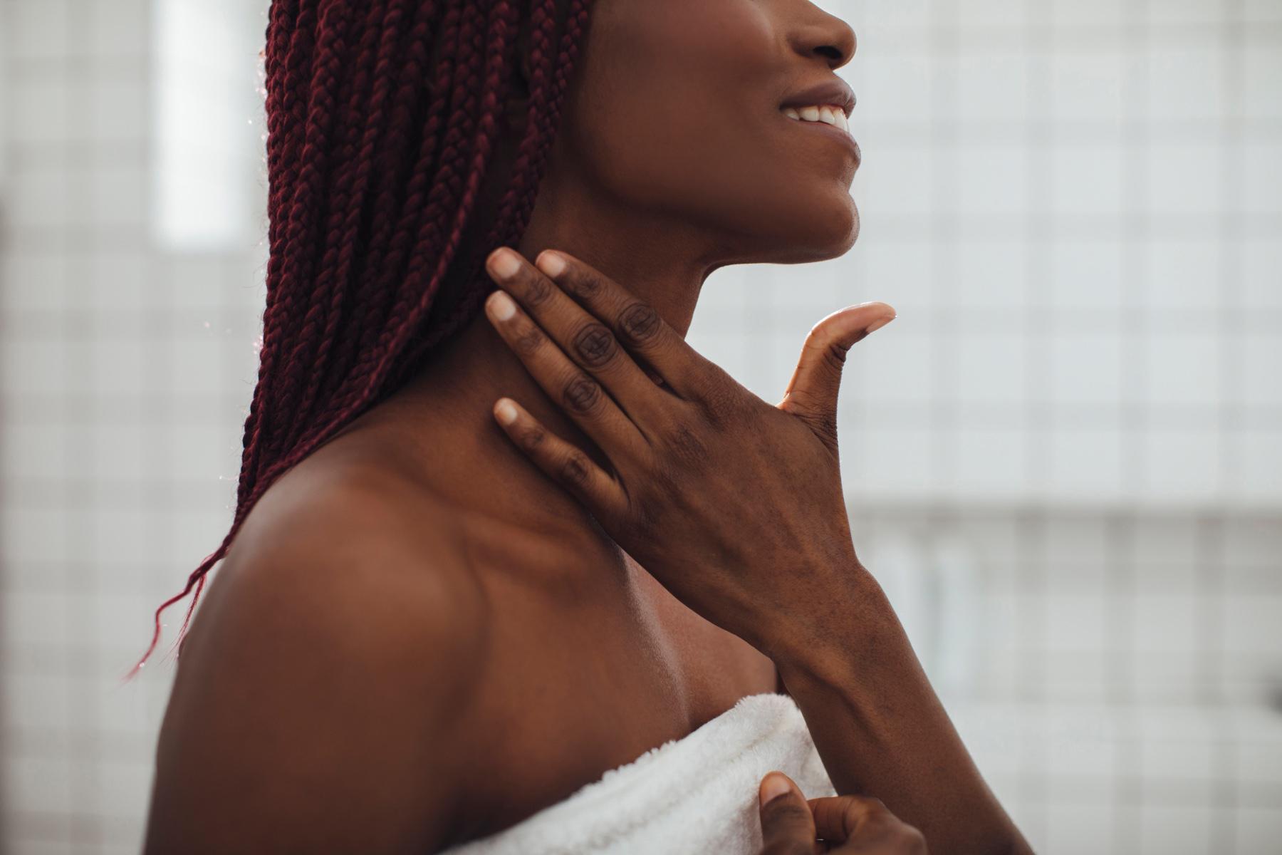 Close-up of woman touching her neck.