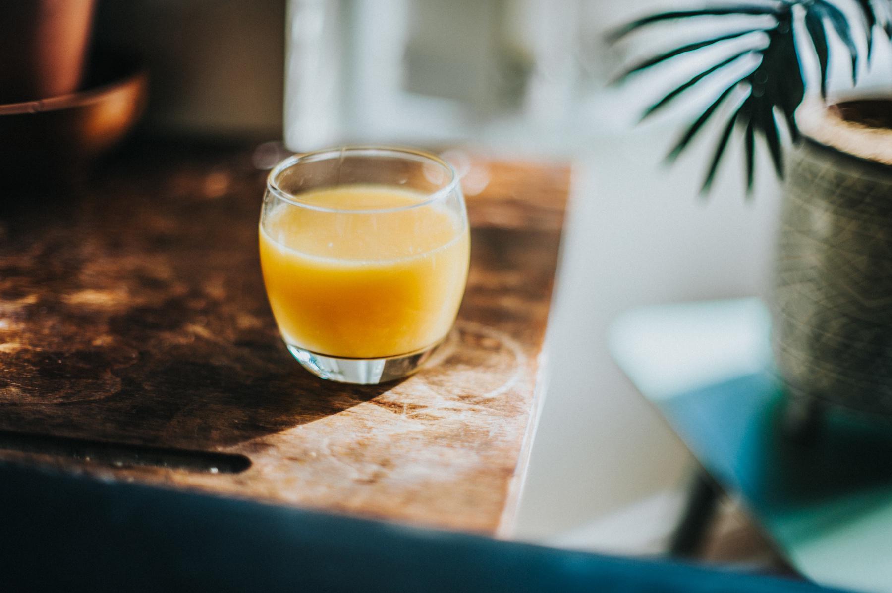 Glass of orange juice on table.