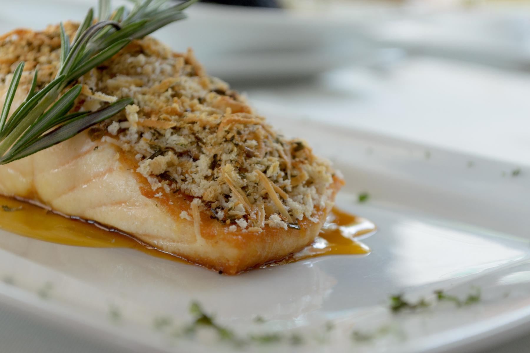 A plate of potato-crusted salmon with dijon shallot sauce.