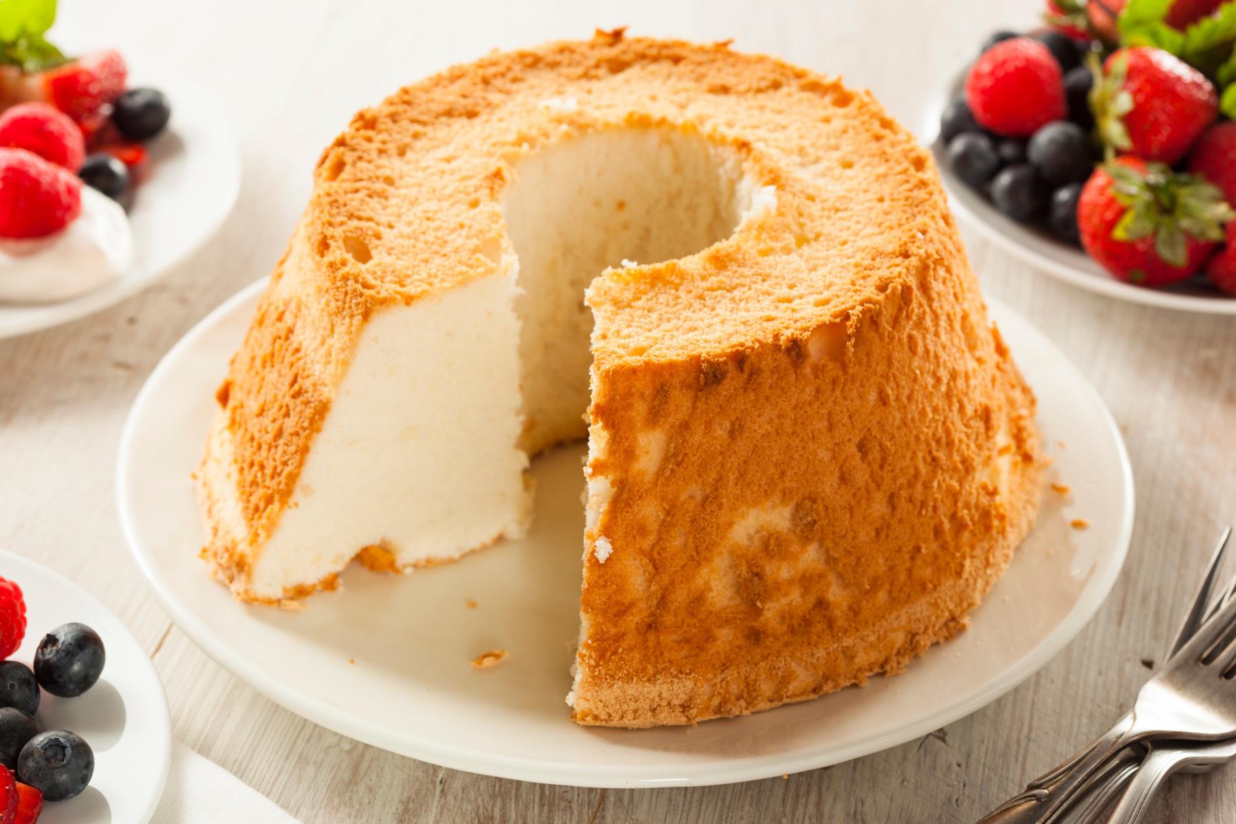 Angel food cake with slice out of it.