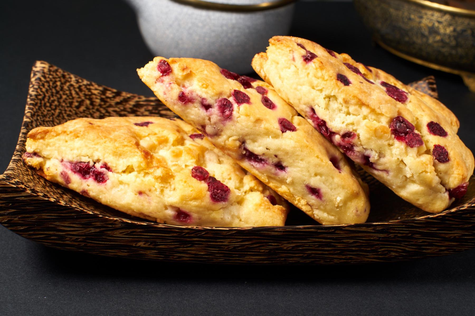 Three scones laying on dark plate.