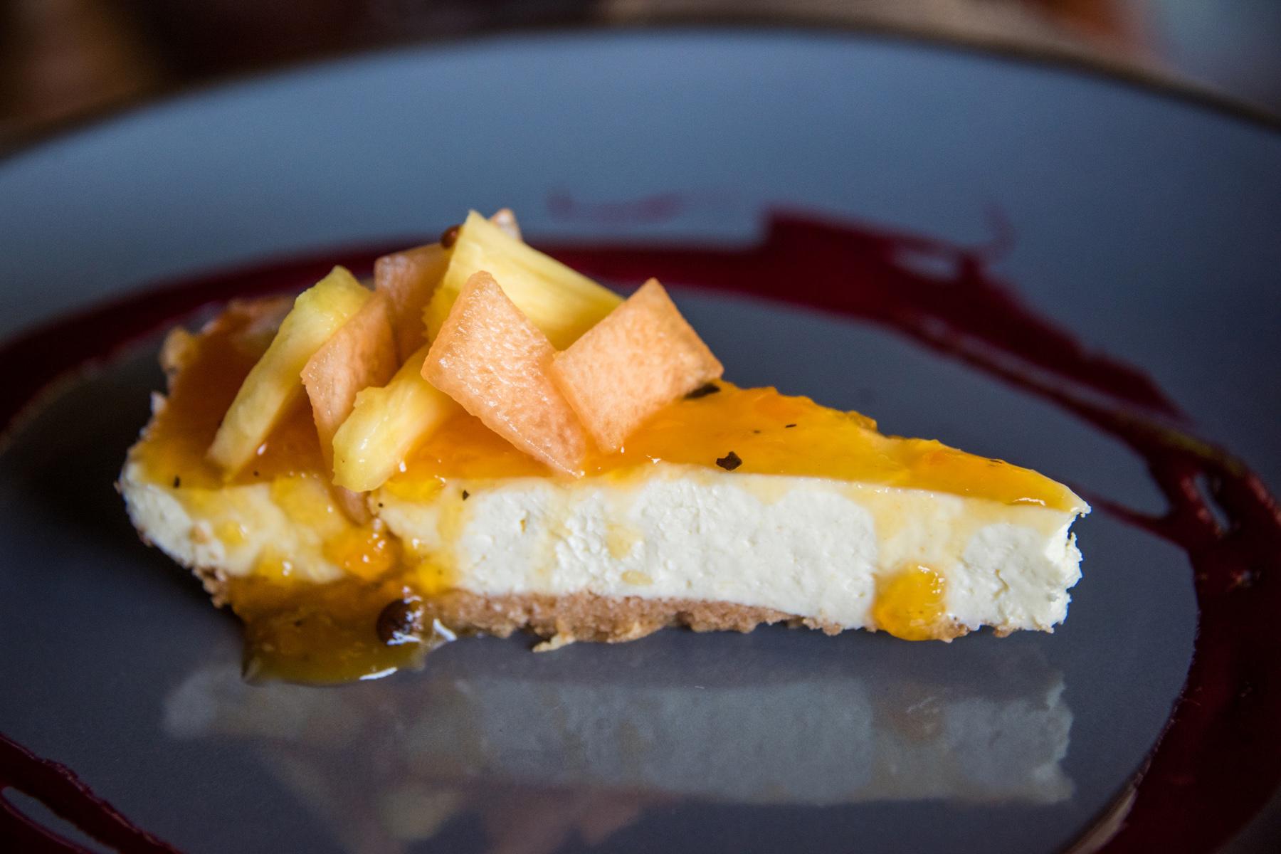 Slice of vanilla cheesecake with fruit on top.