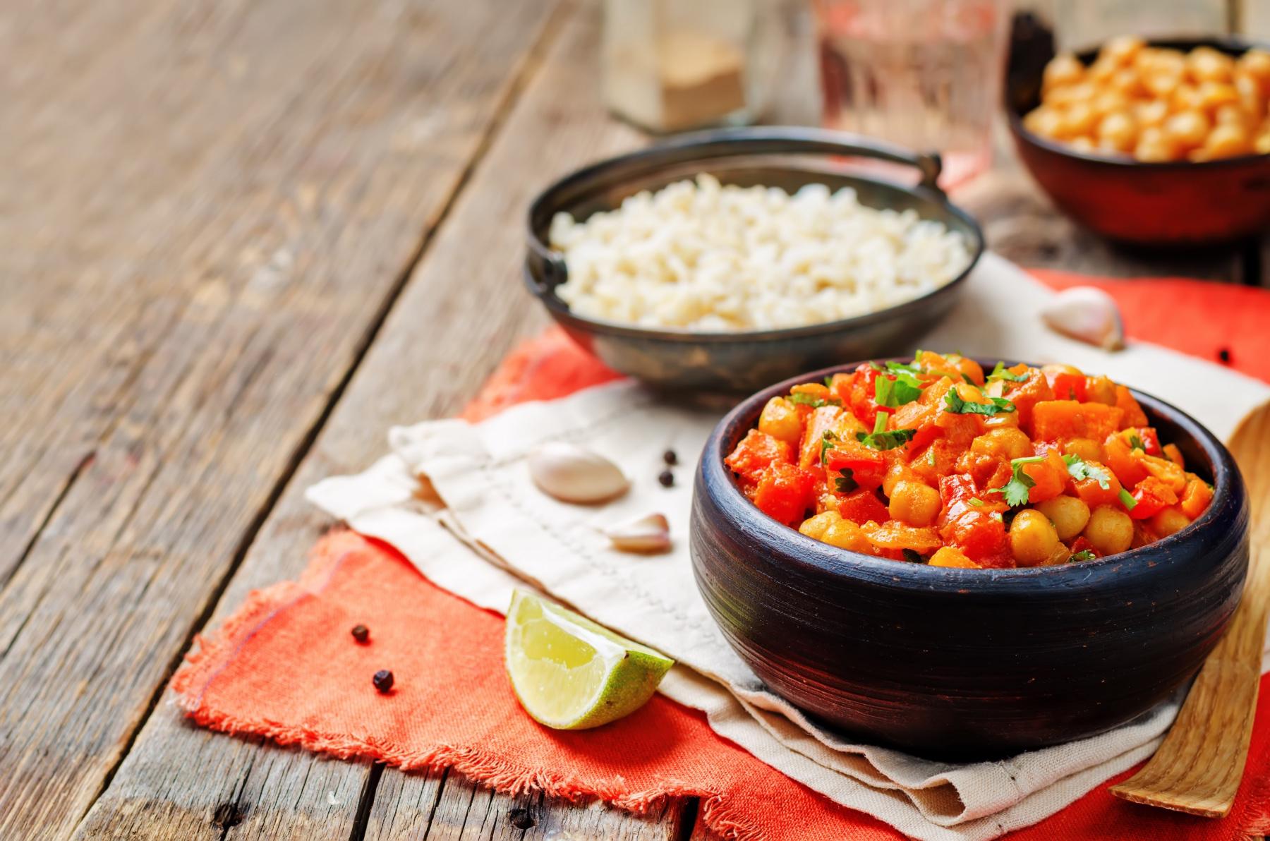 Two bowls, one filled with spicy garbanzo beans and one filled with rice.