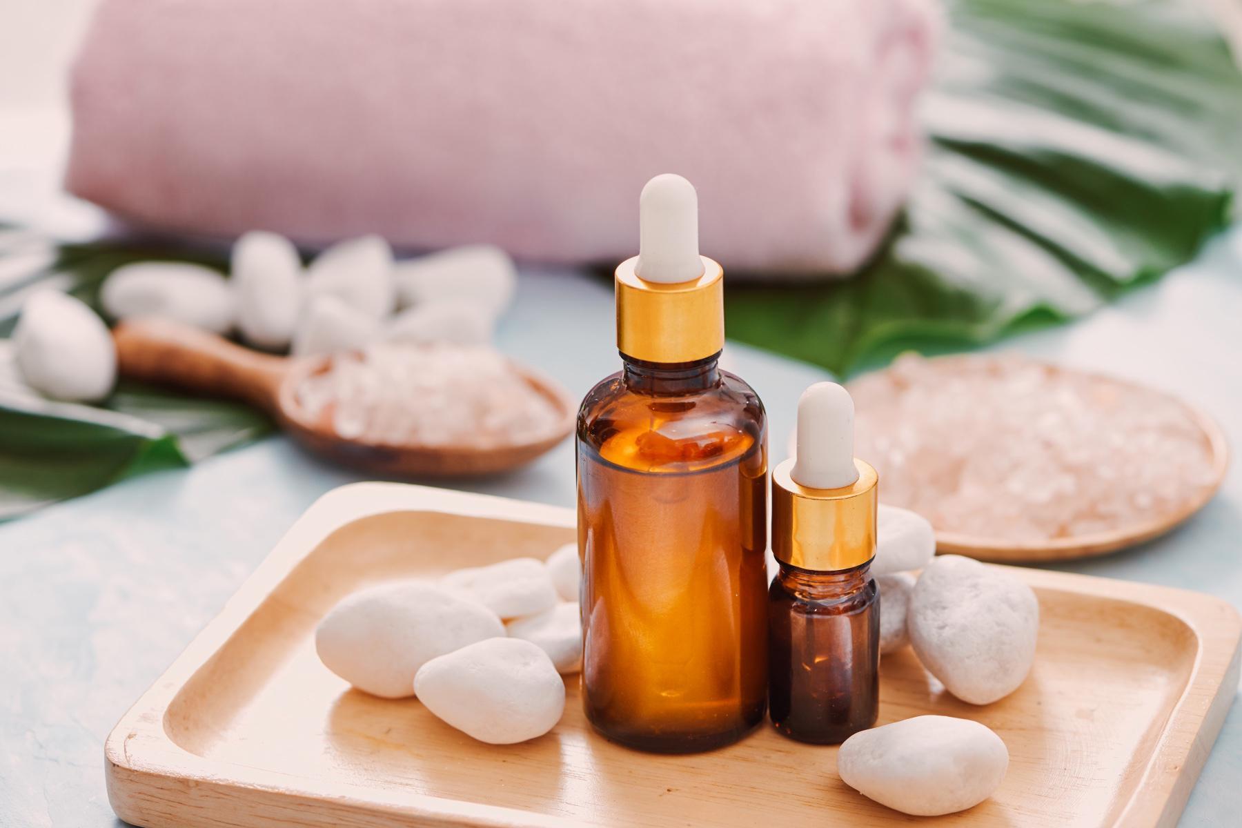 Two bottles of essential oils placed on a wooden board.