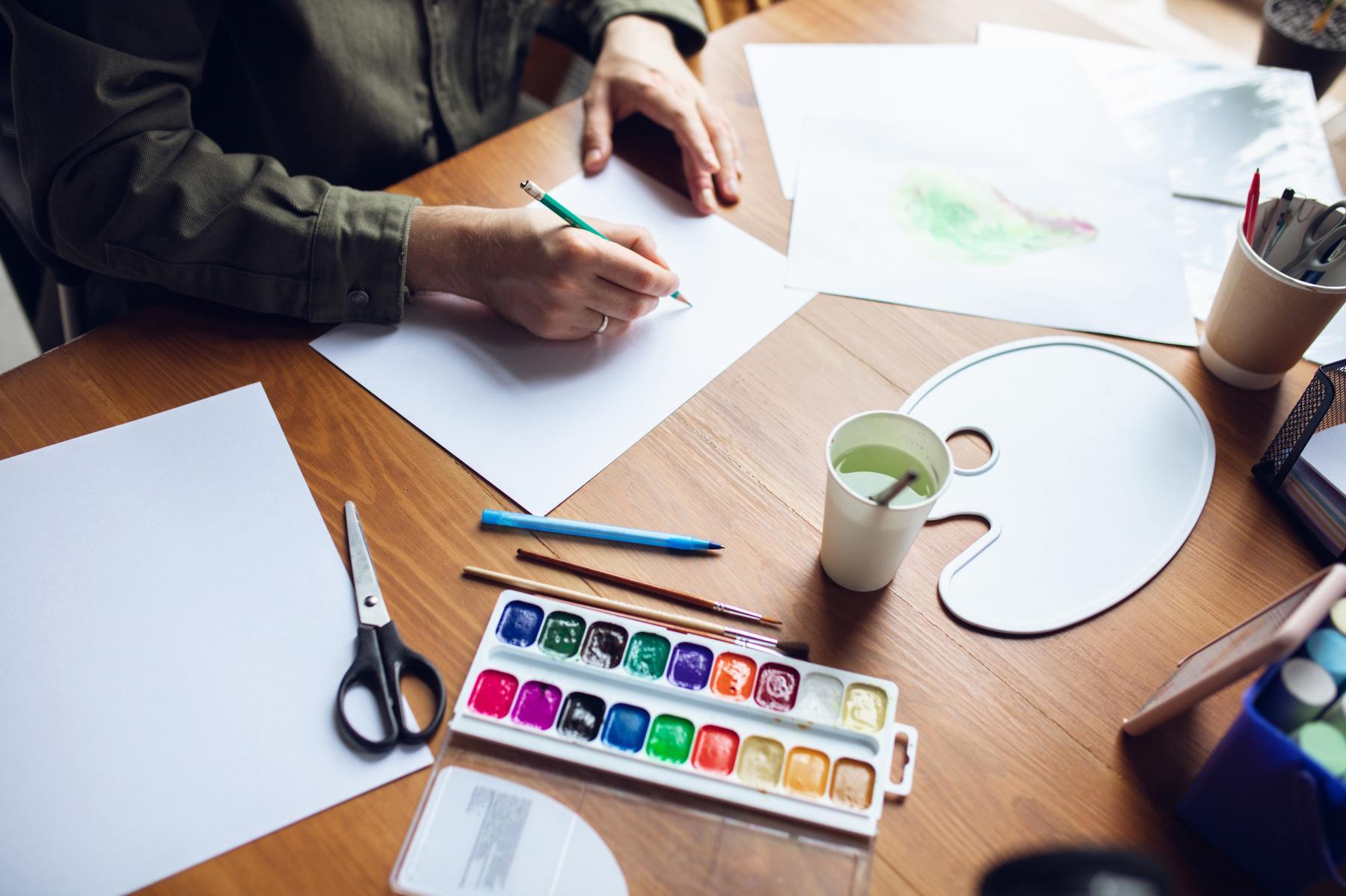 Someone sitting at their desk with painting tools.
