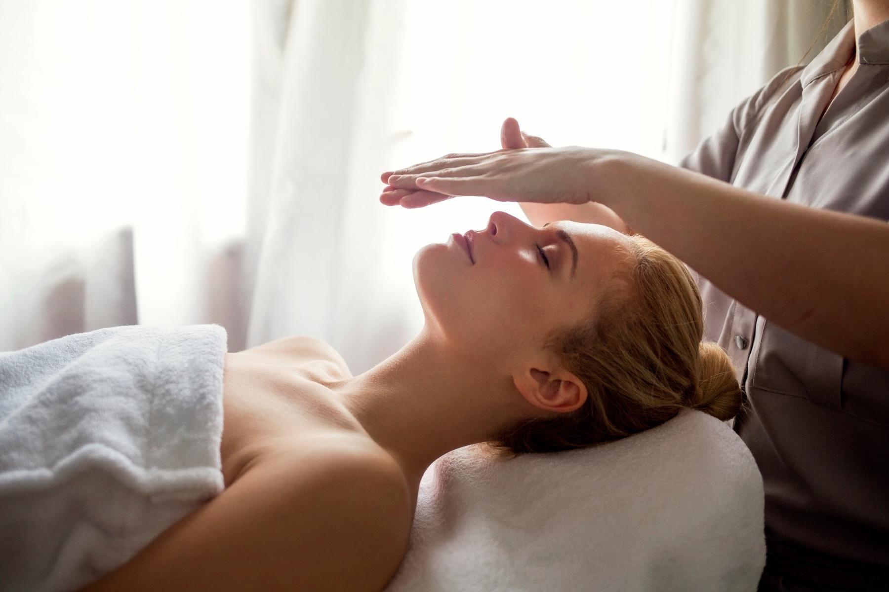 A woman receiving a Reiki treatment.