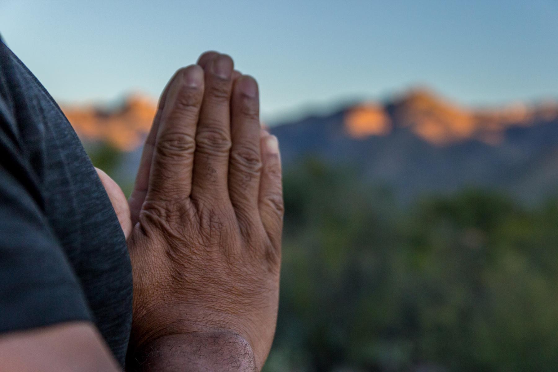 A closeup of a mature man's hands in prayer.