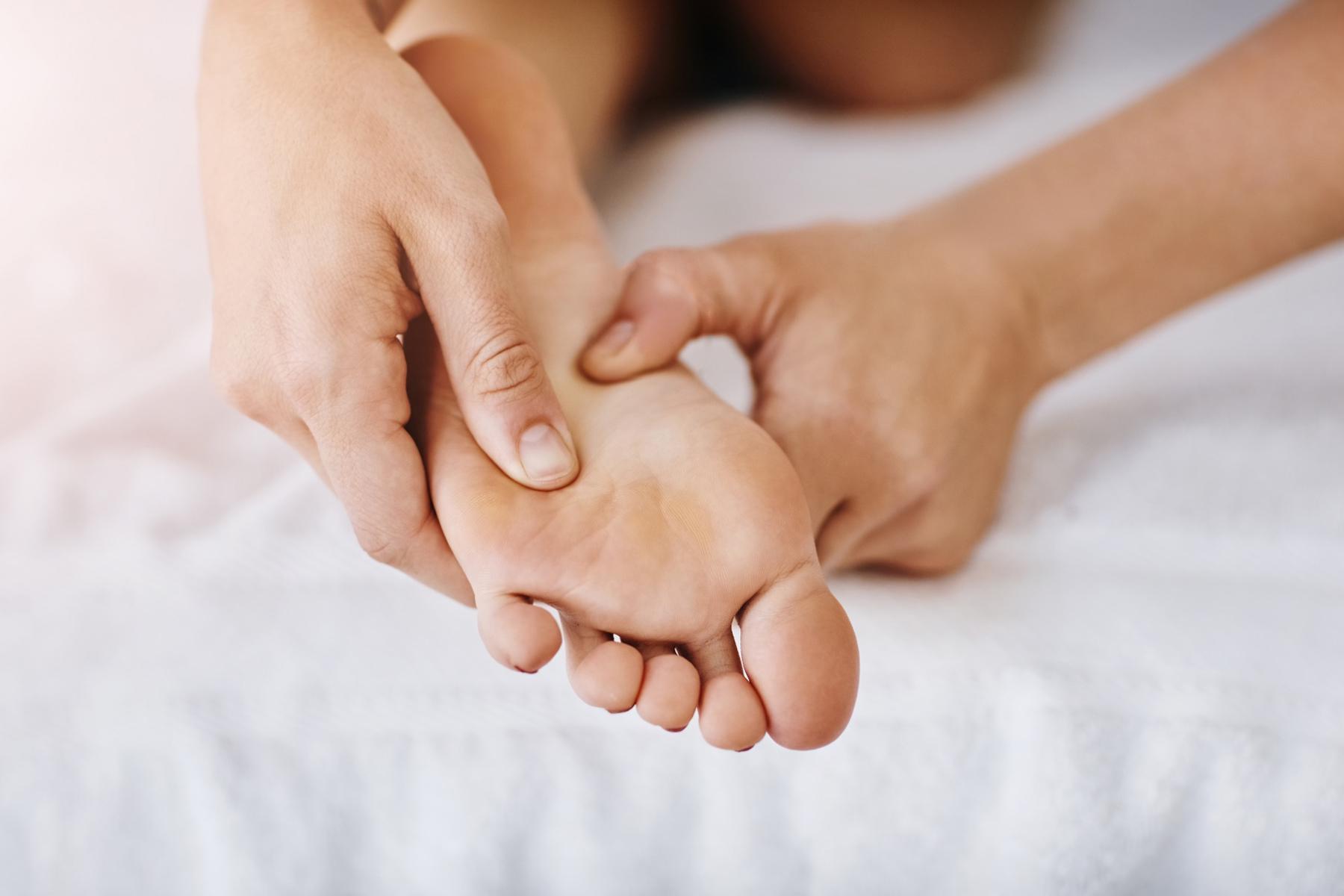 A masseuse rubbing someone's foot.