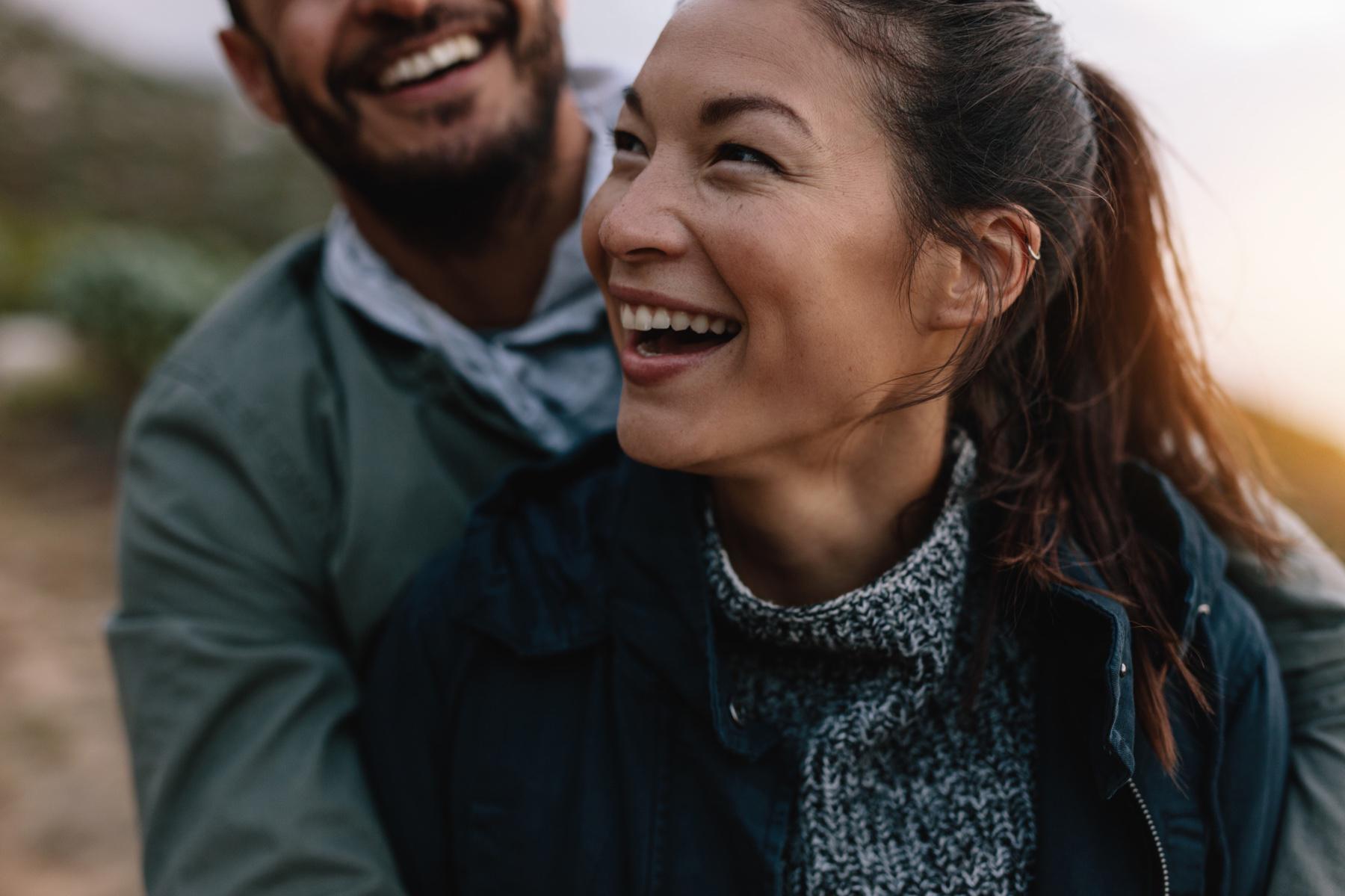 Close-up of man and woman smiling together.