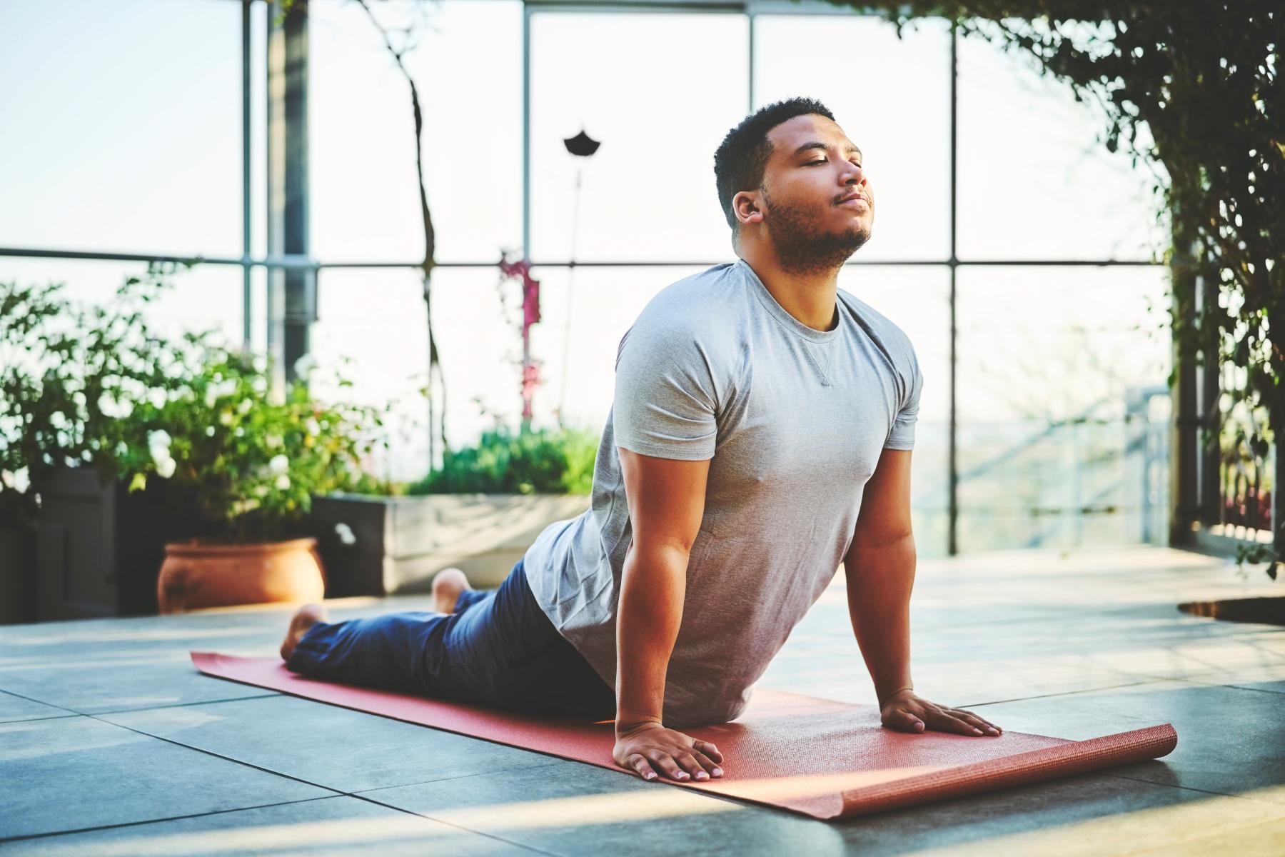 Man on yoga mat in sphinx pose.