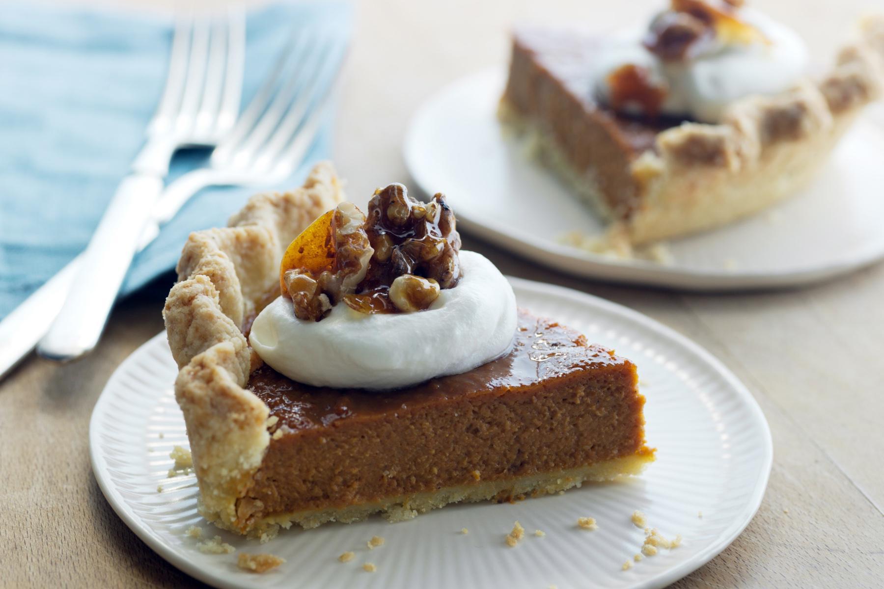 close-up of slice of pumpkin pie with whipped cream on top
