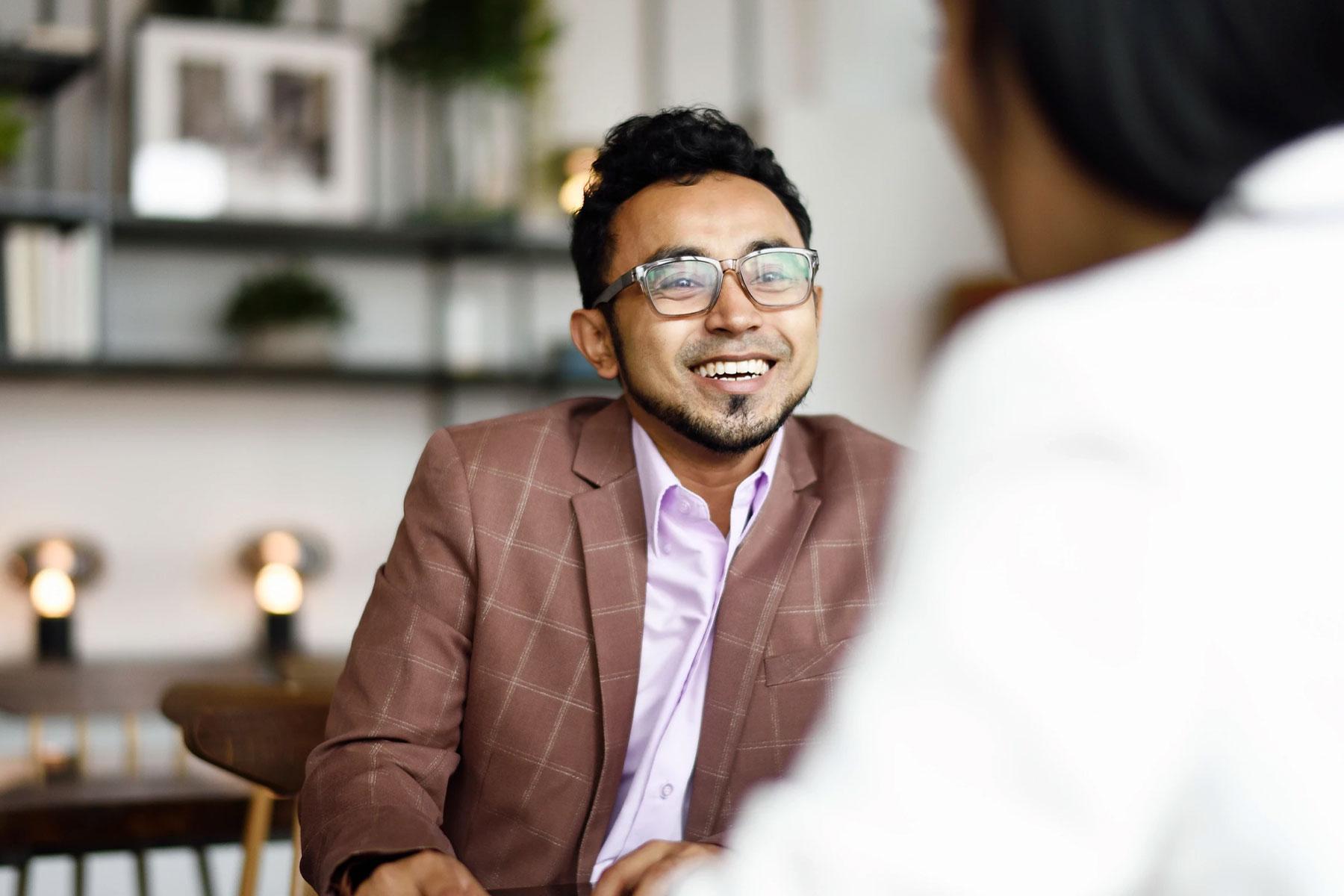 Man smiling while having a conversation.