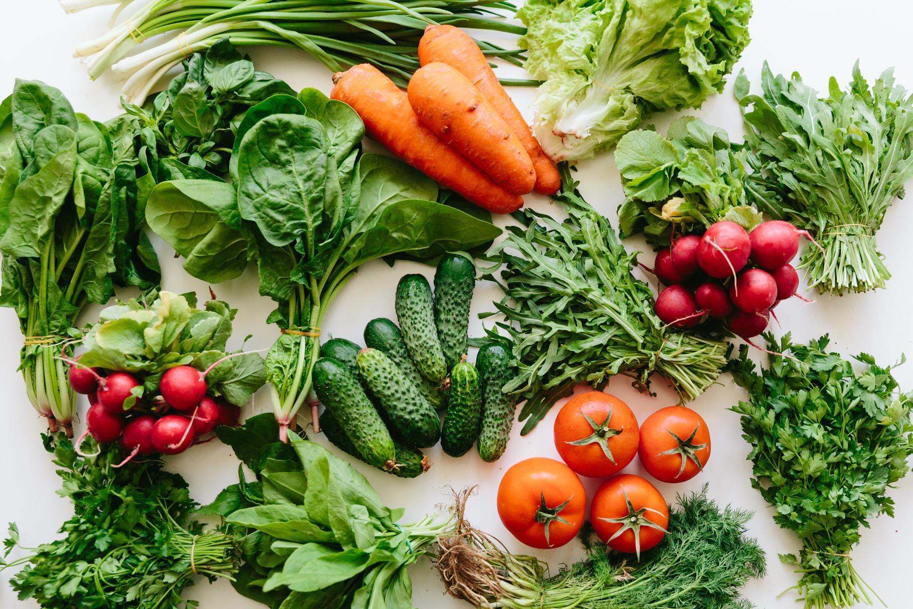 overhead view of fresh vegetables on white table