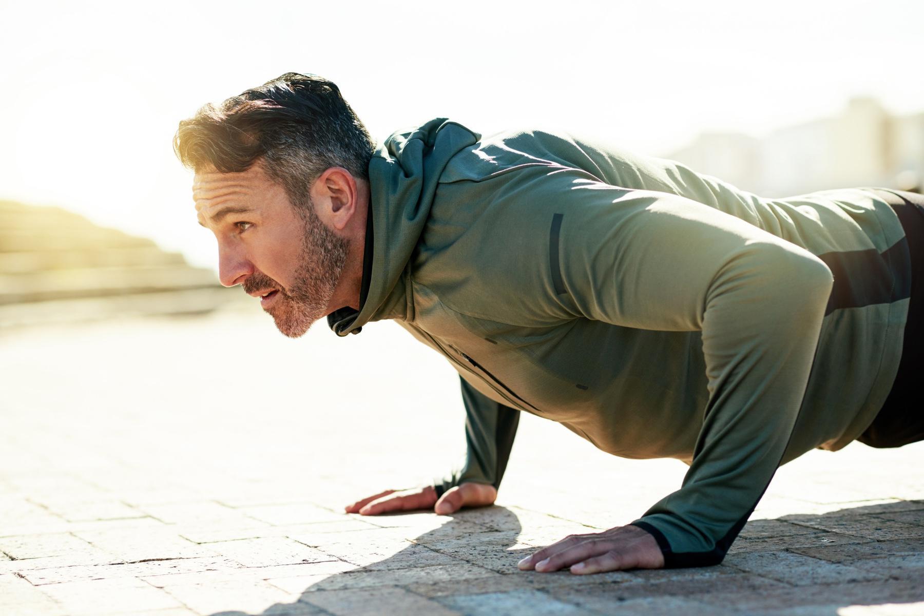 close-up of middle aged man doing a push-up from the side
