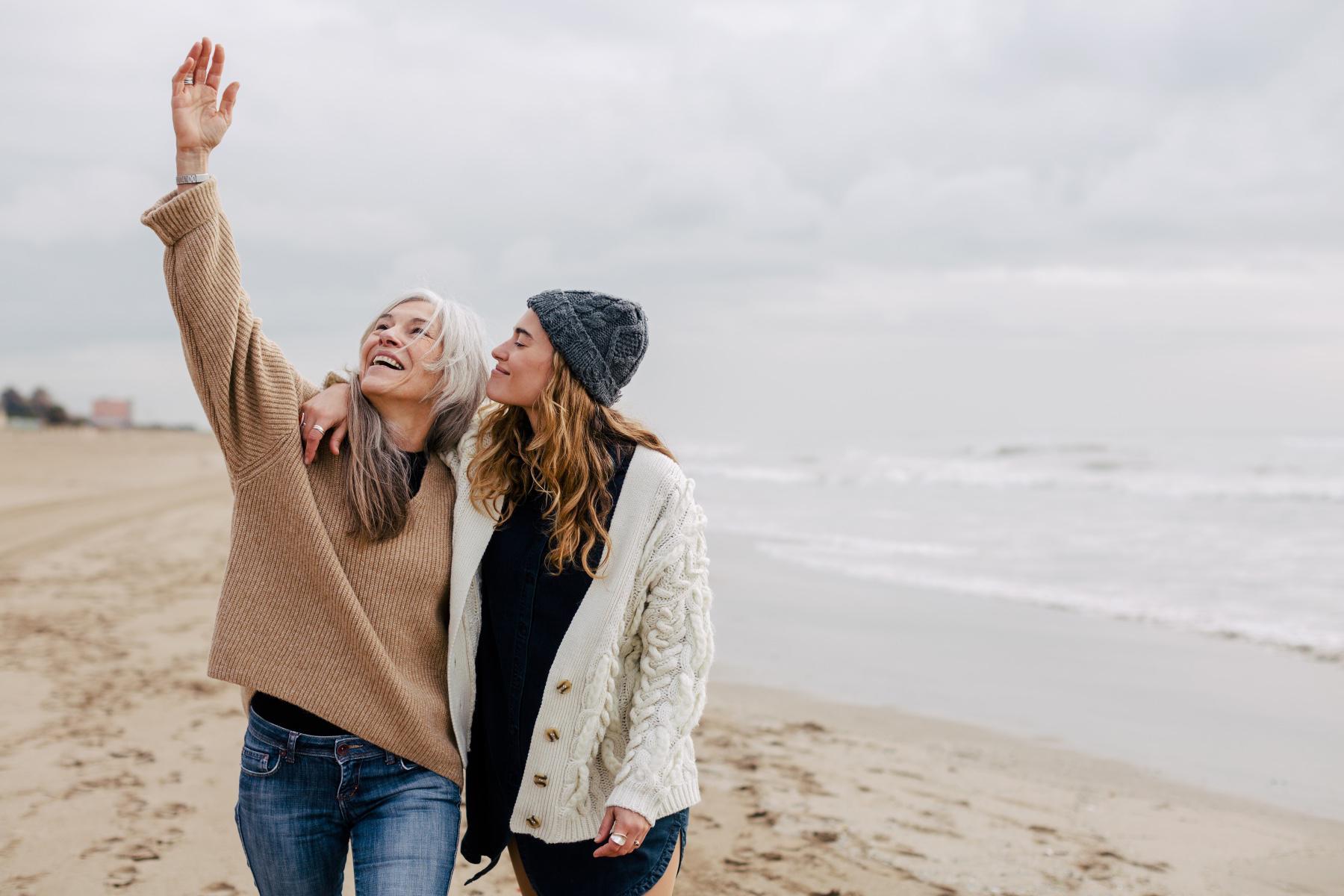 A mature mother and her adult daughter at the beach.
