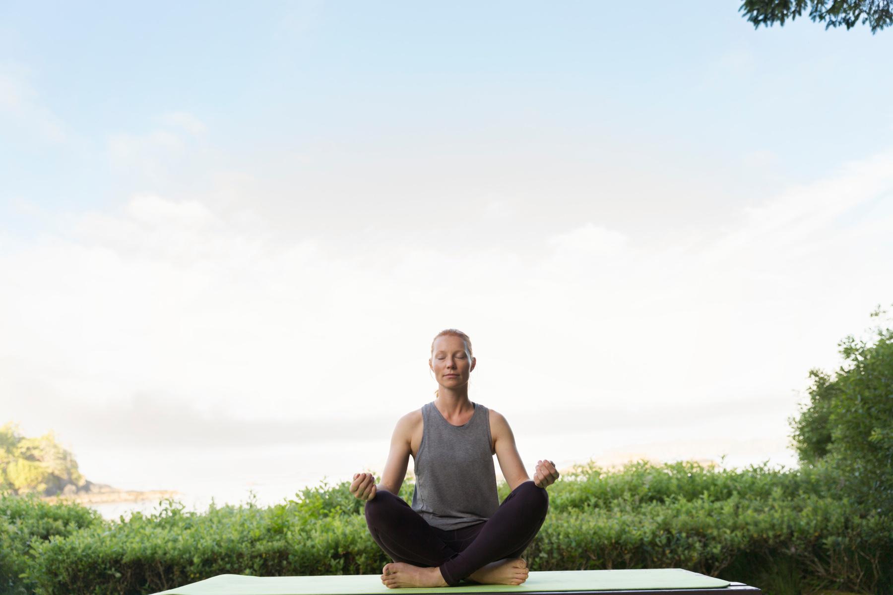 Woman meditating in a park.