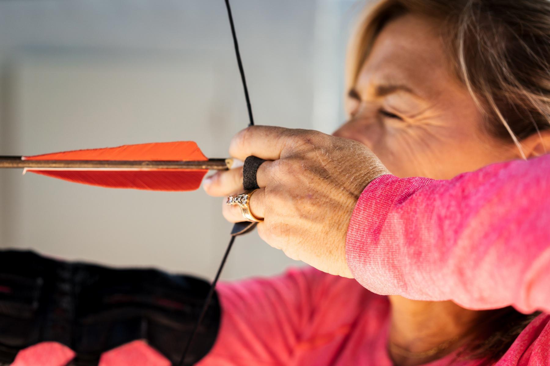 A woman shooting a bow and arrow.