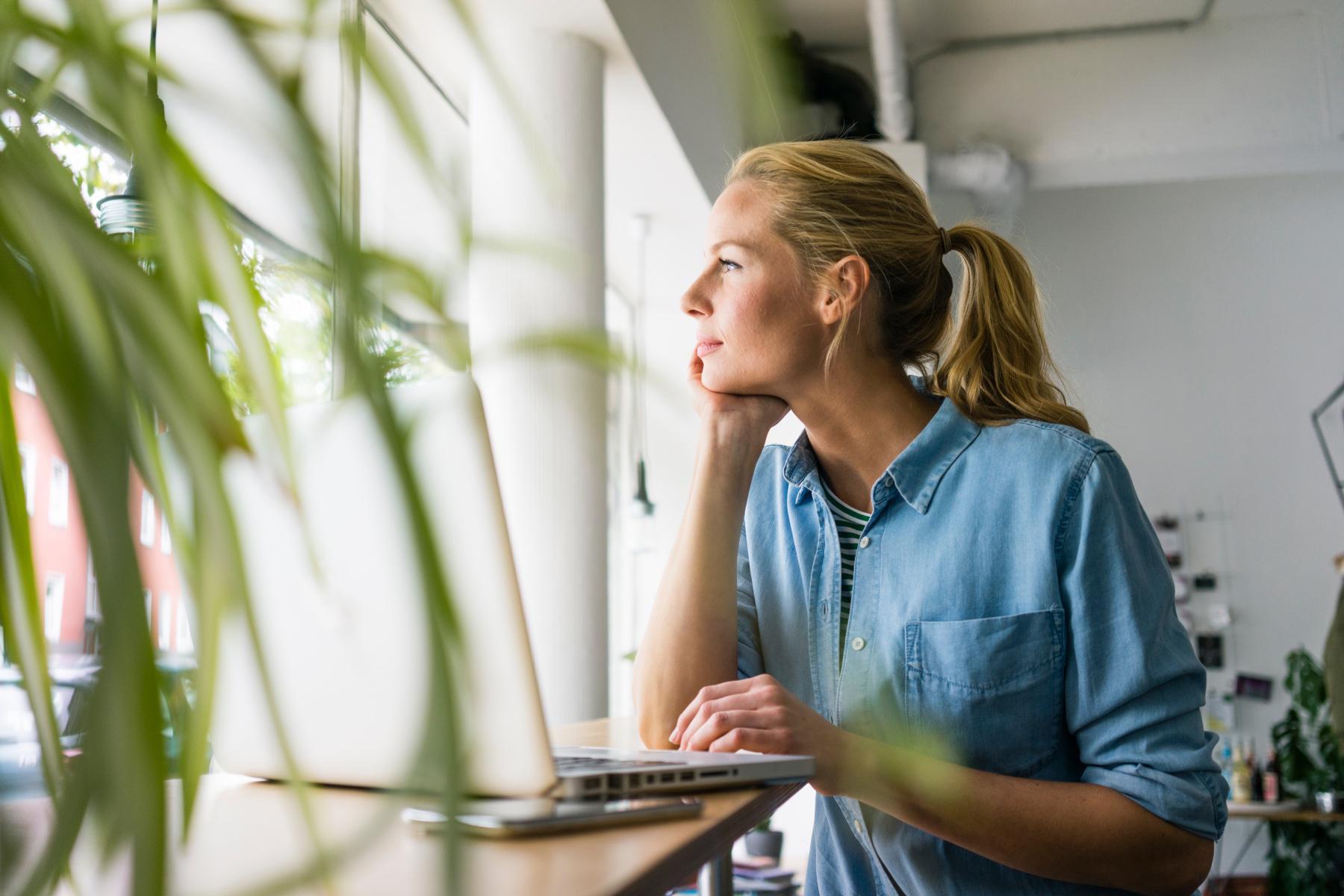 Woman looking outside her office window.