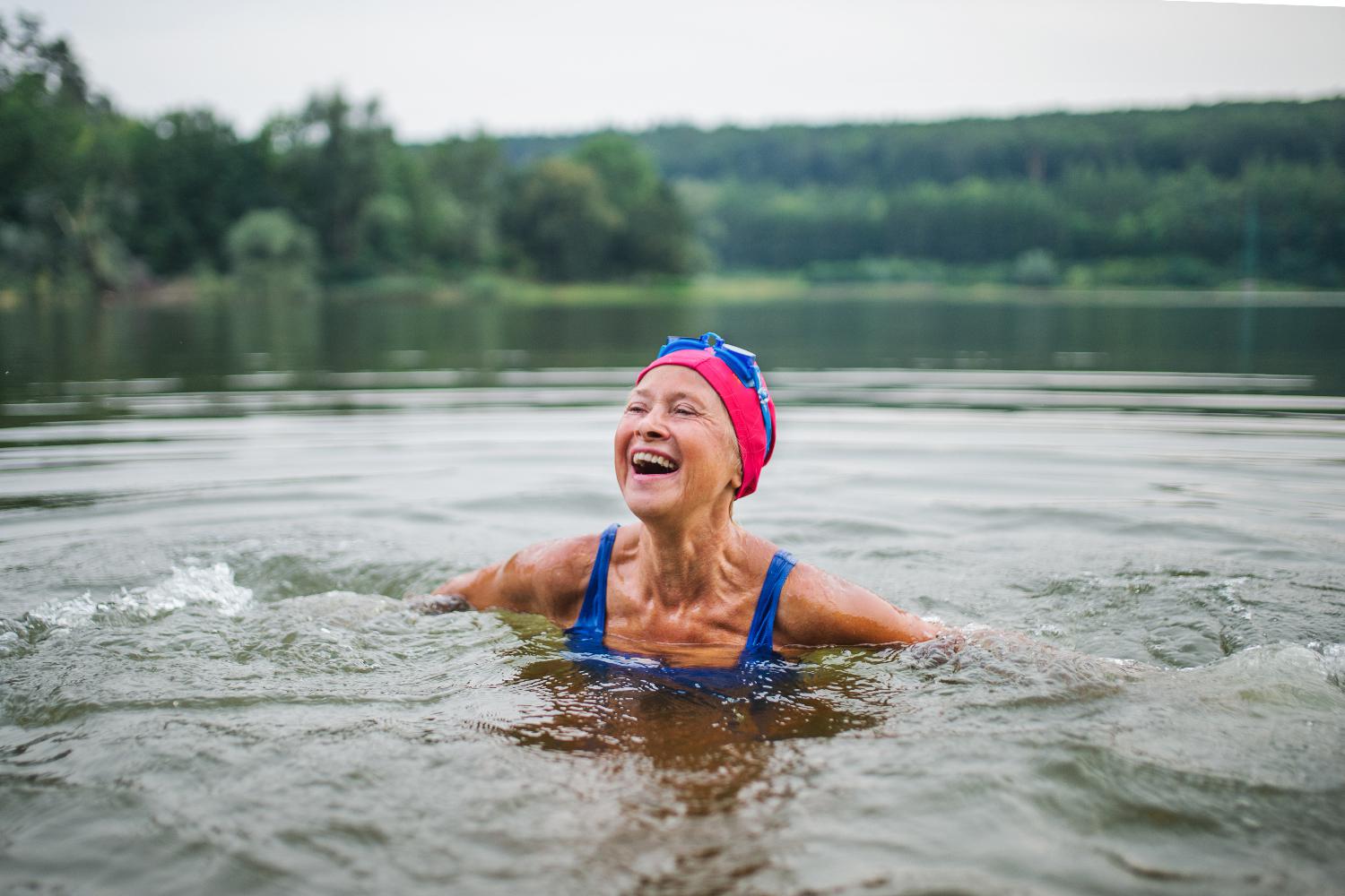 An elderly woman swimming in a lake