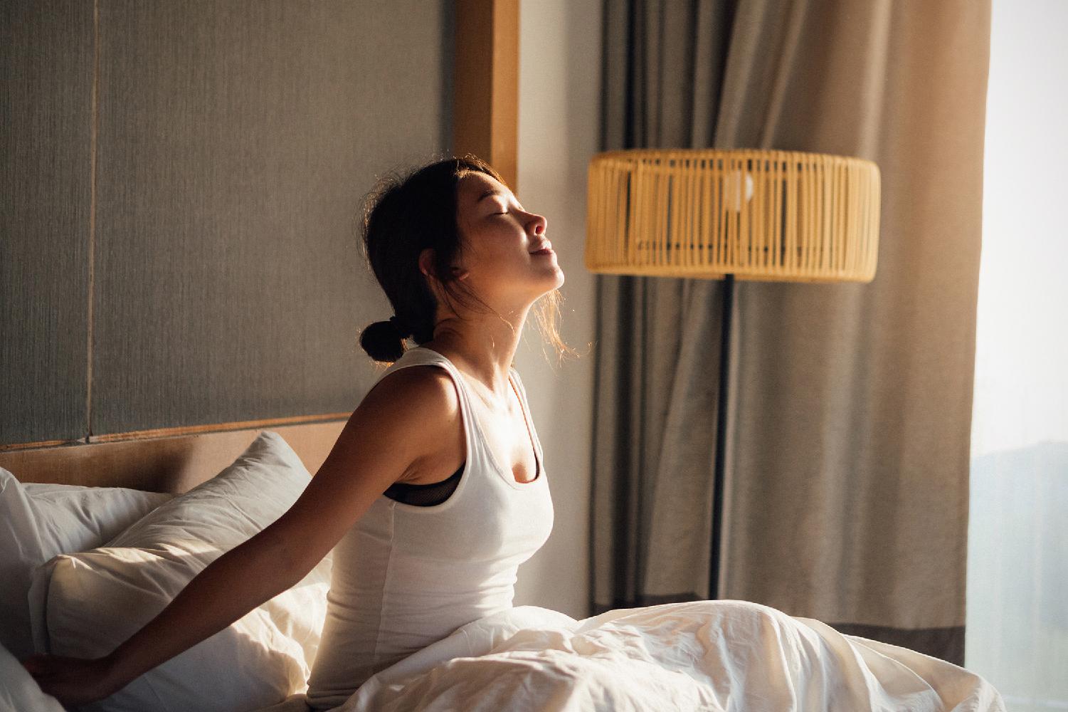A woman waking up refreshed after a good night's sleep
