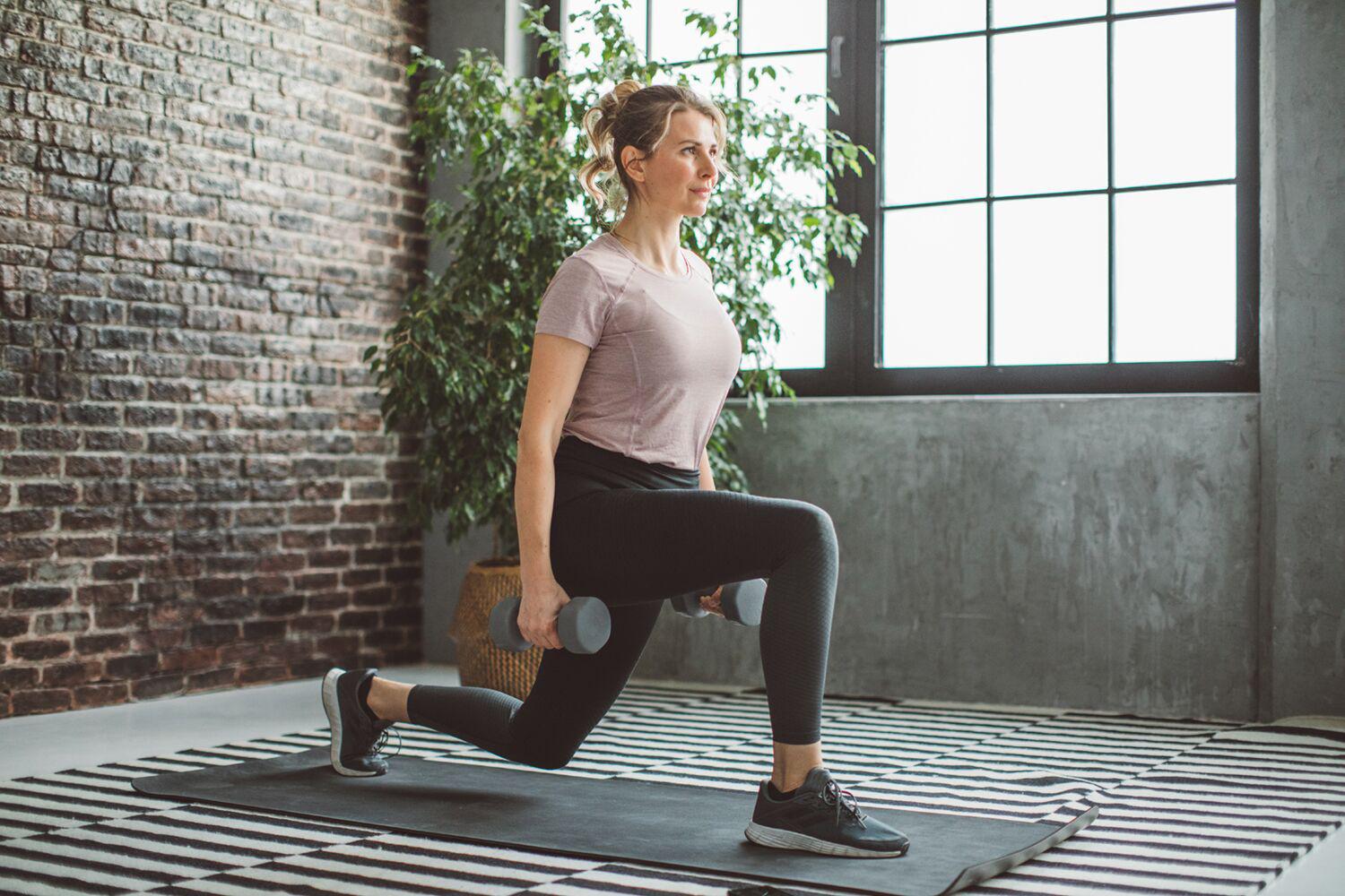 woman doing lunges with dumbbells