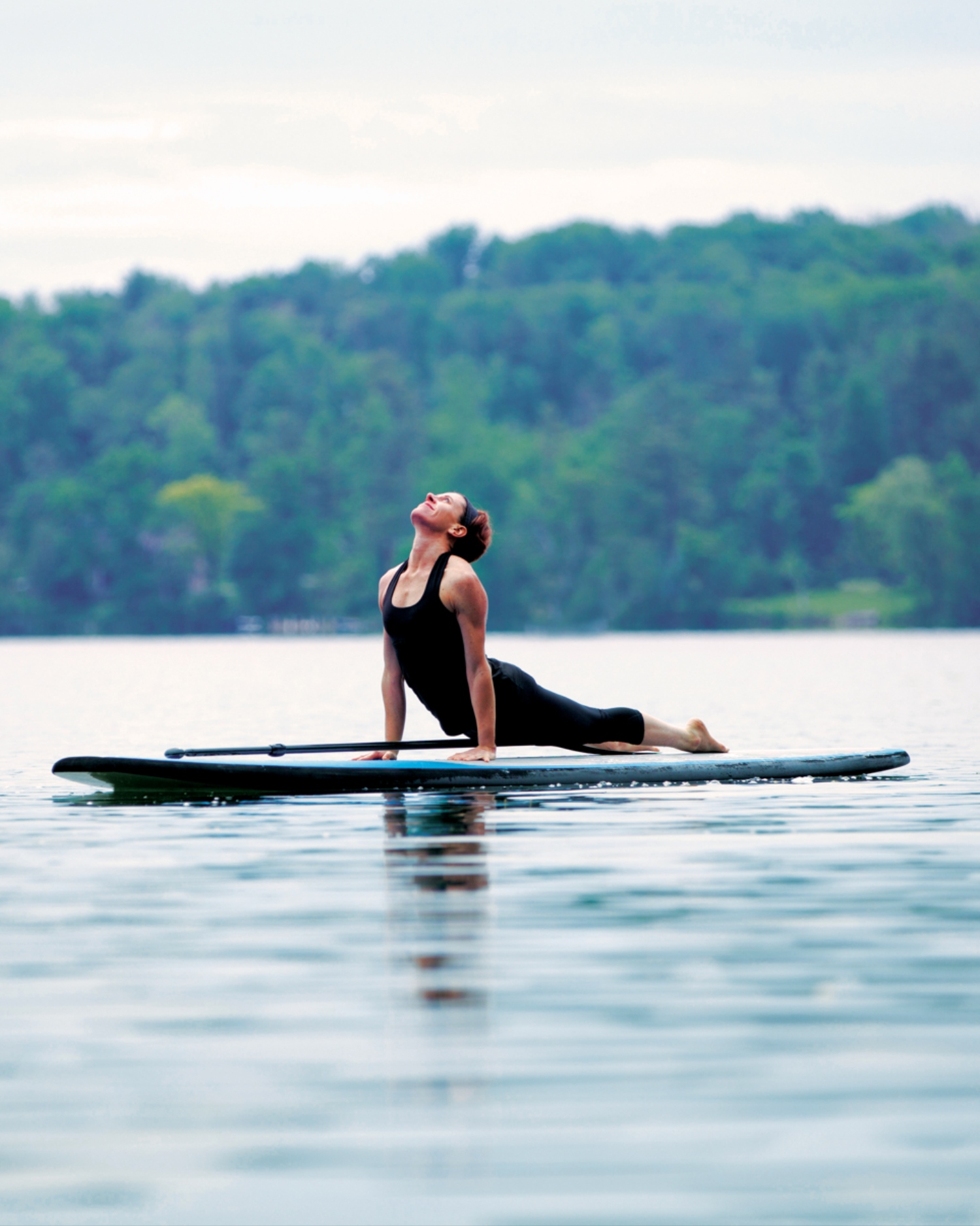 A woman doing paddleboard yoga