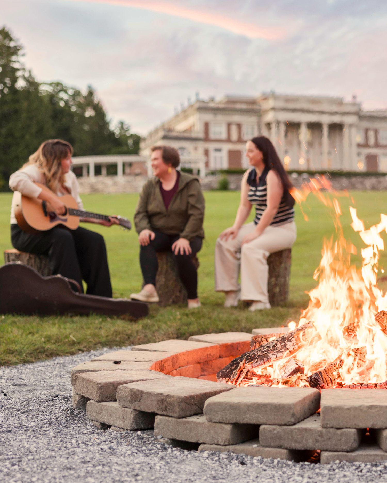 A group having a sing along by a campfire
