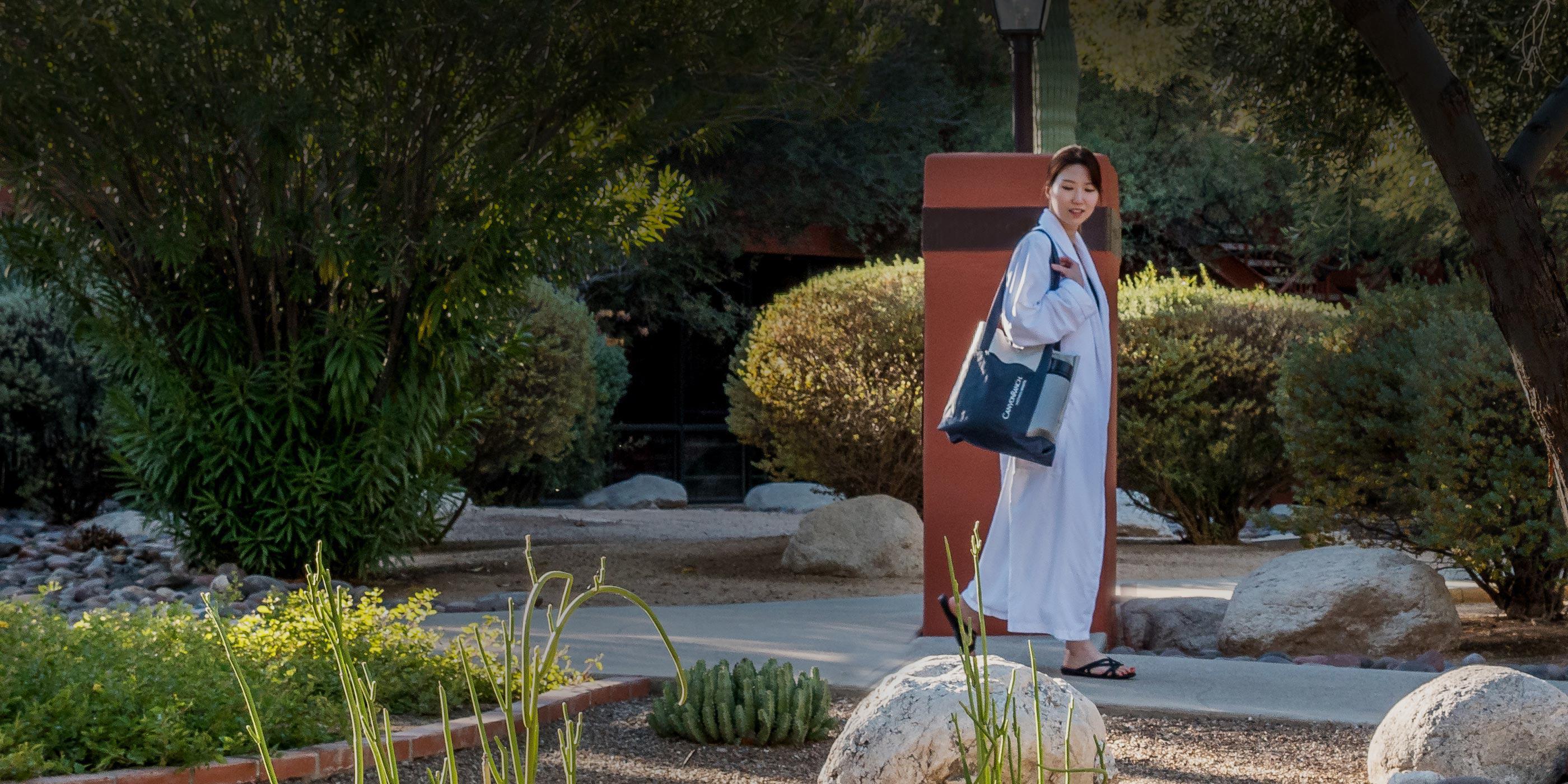 Woman walking around the Tucson property in a robe.