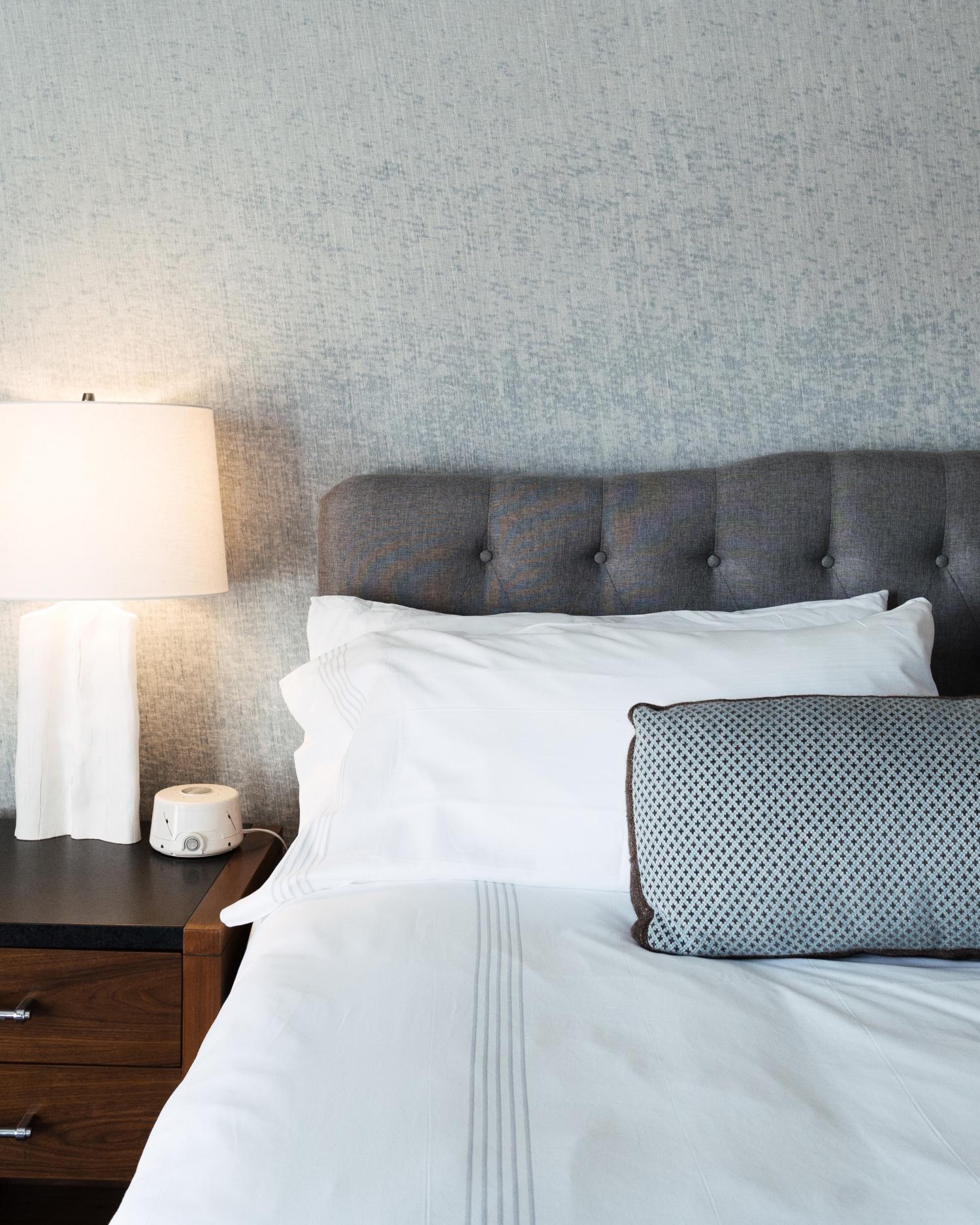 A room featuring bed and bedside table with lamp